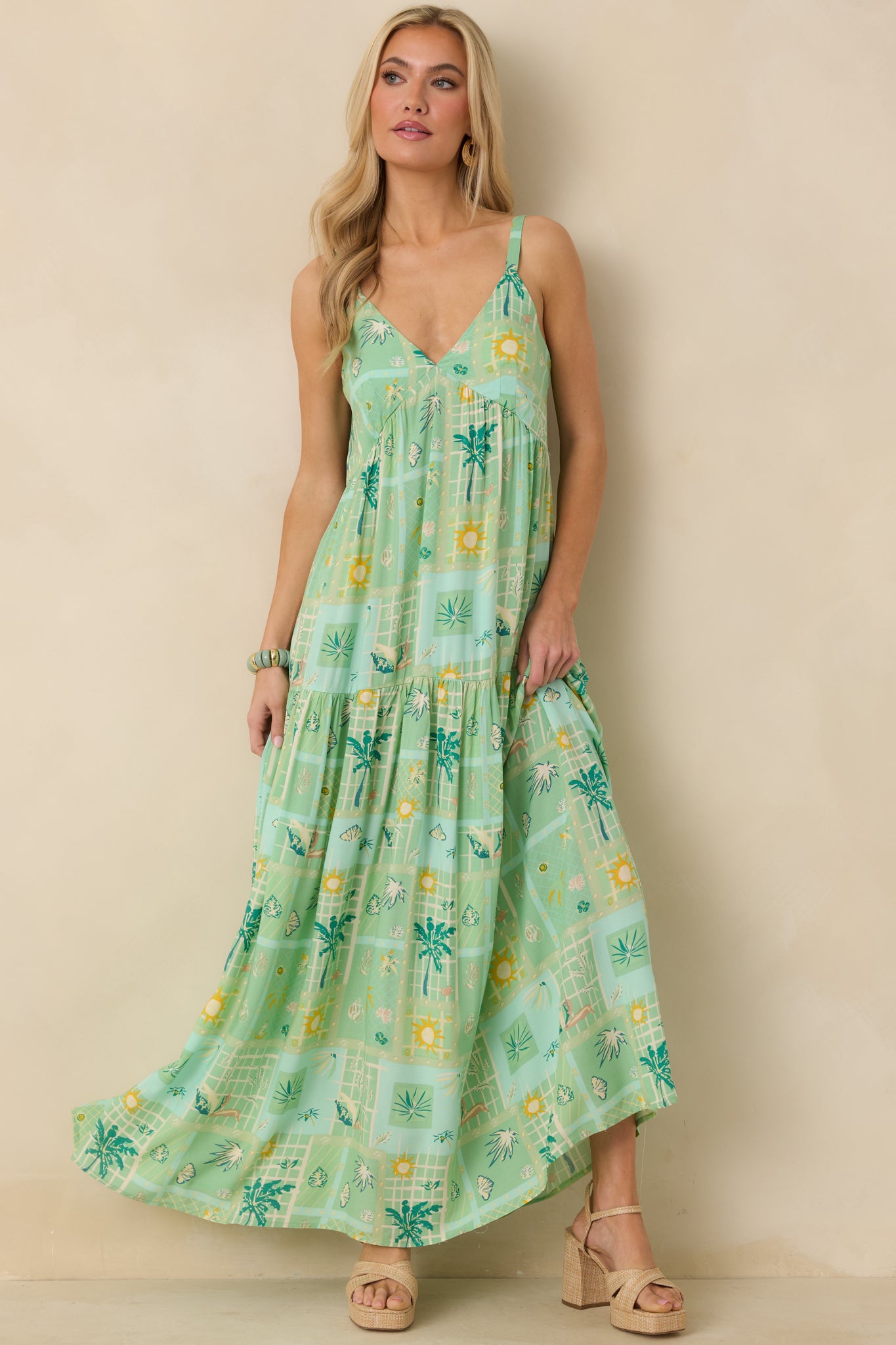 Full-length green multicolor dress showcasing a defined empire waist and breezy, layered skirt.