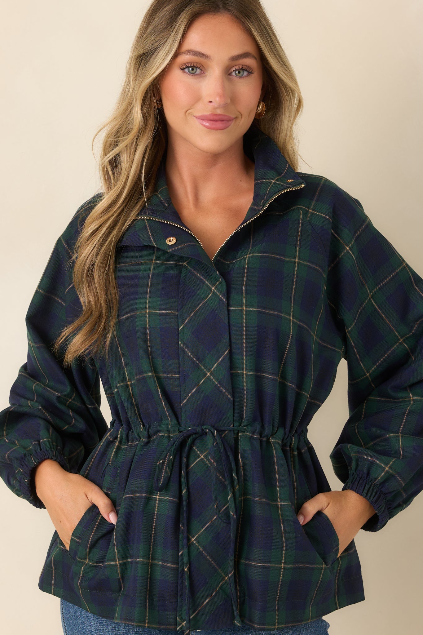 Detailed view of the plaid jacket showcasing the oversized front patch pockets, drawstring waist, and practical utility-inspired construction.