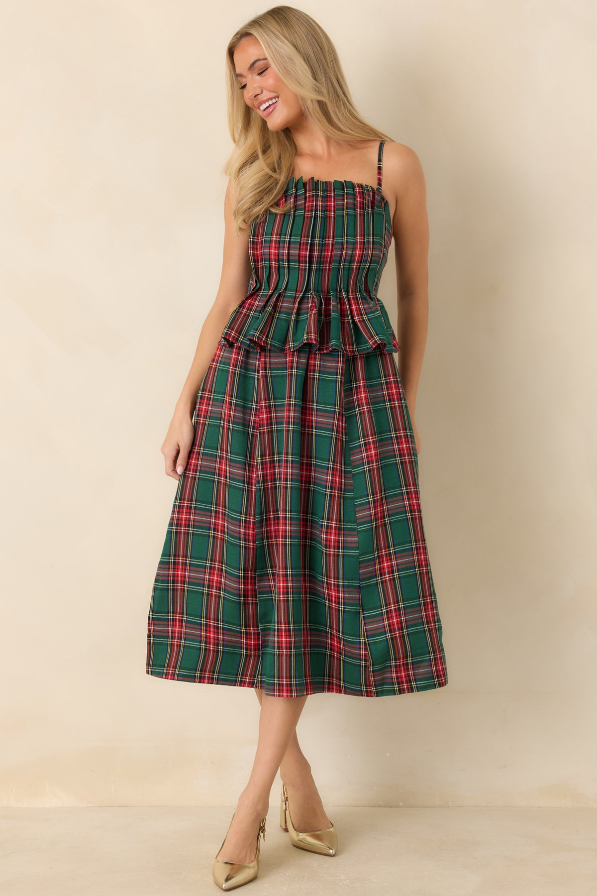 Festive green plaid dress with a pleated bodice, fitted waist, and flared midi-length skirt.