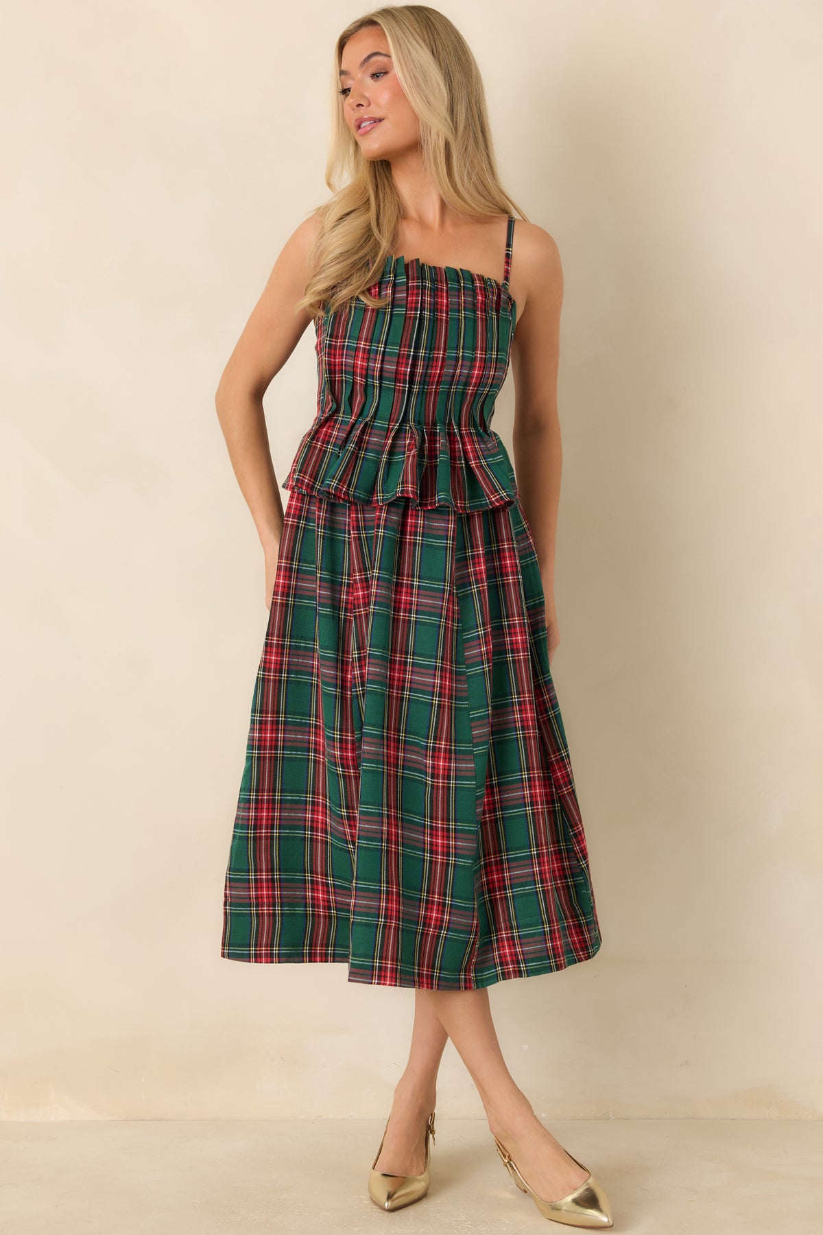 Green plaid midi dress featuring a pleated upper bodice, ruffled trim, and a softly flared silhouette.