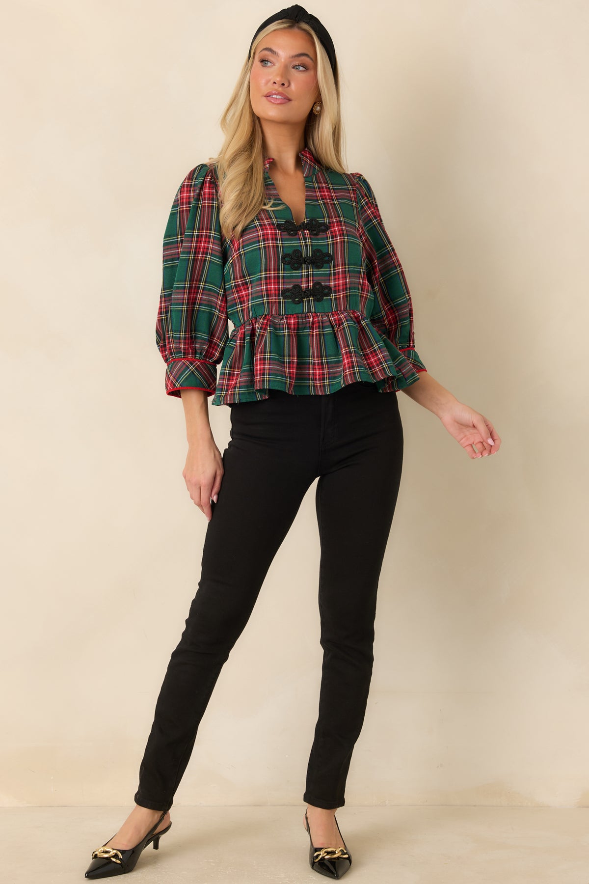 Green and red plaid top with a stand collar, three black braided frog closures, and a gathered peplum hem.