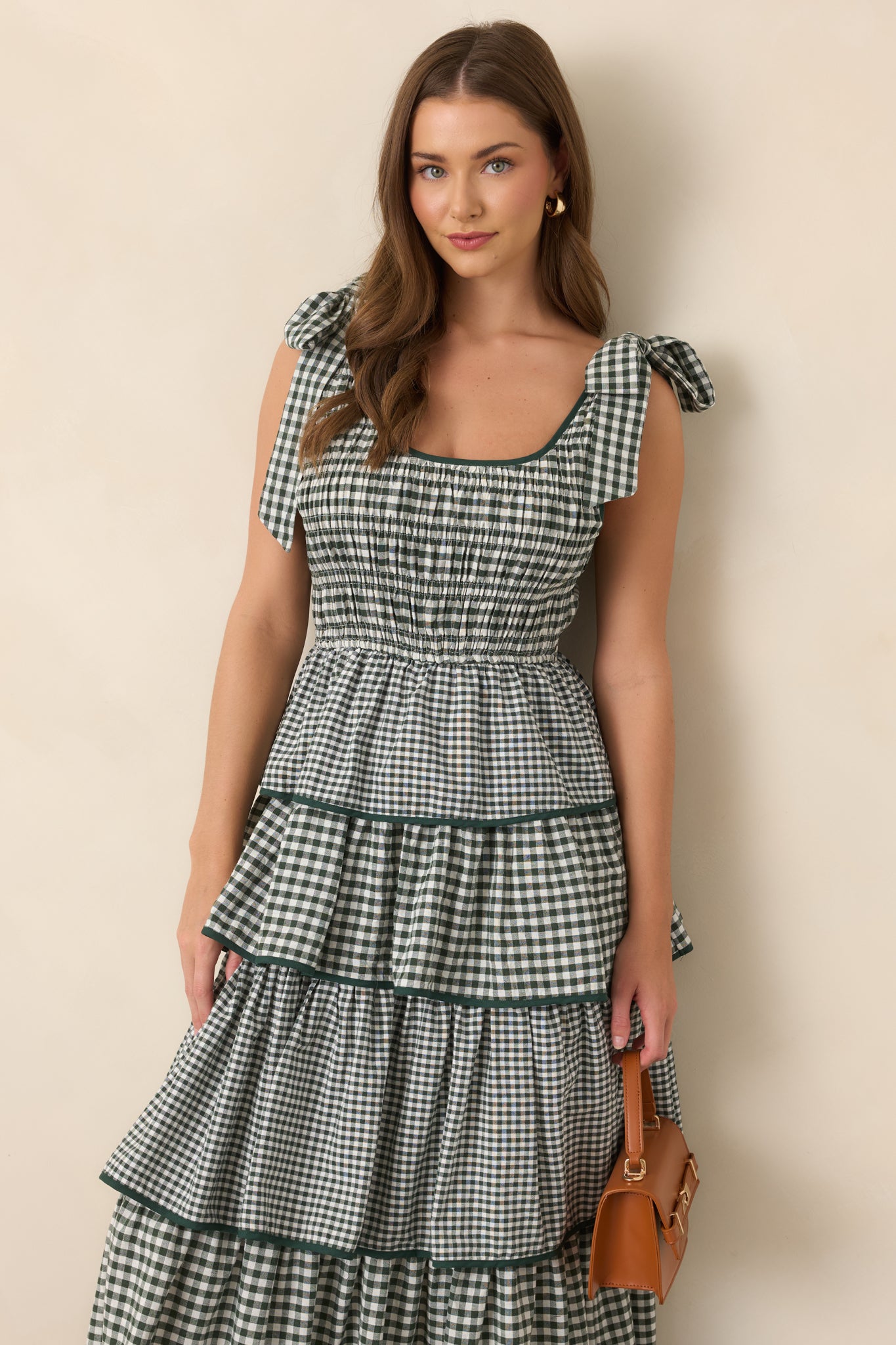 Green dress highlighting the scoop neckline, fixed shoulder ties, smocked bodice, and elasticized waist.