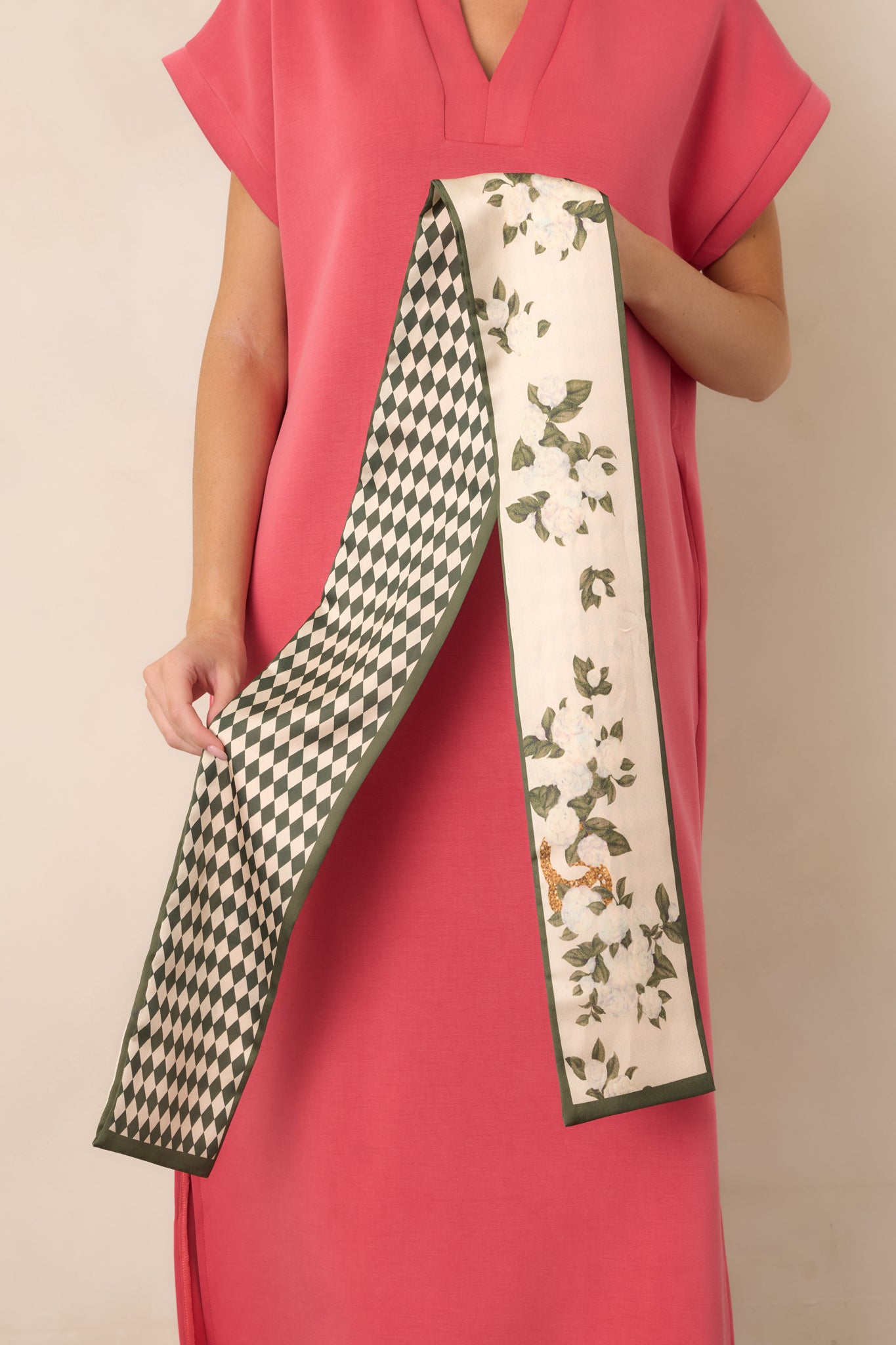Long, slender hair scarf showcasing an elegant green-toned pattern, silky finish, and versatile twilly shape.