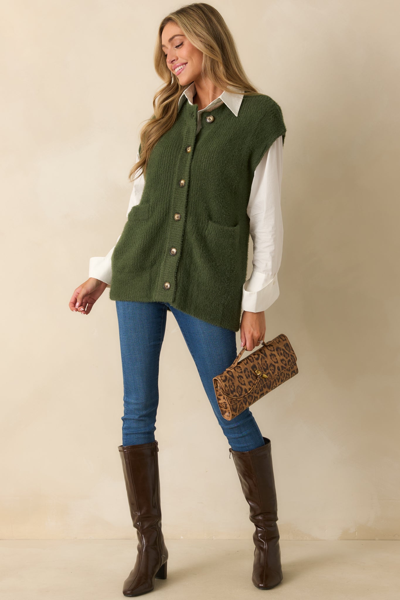 Green sleeveless knit cardigan with front button closures and relaxed fit.