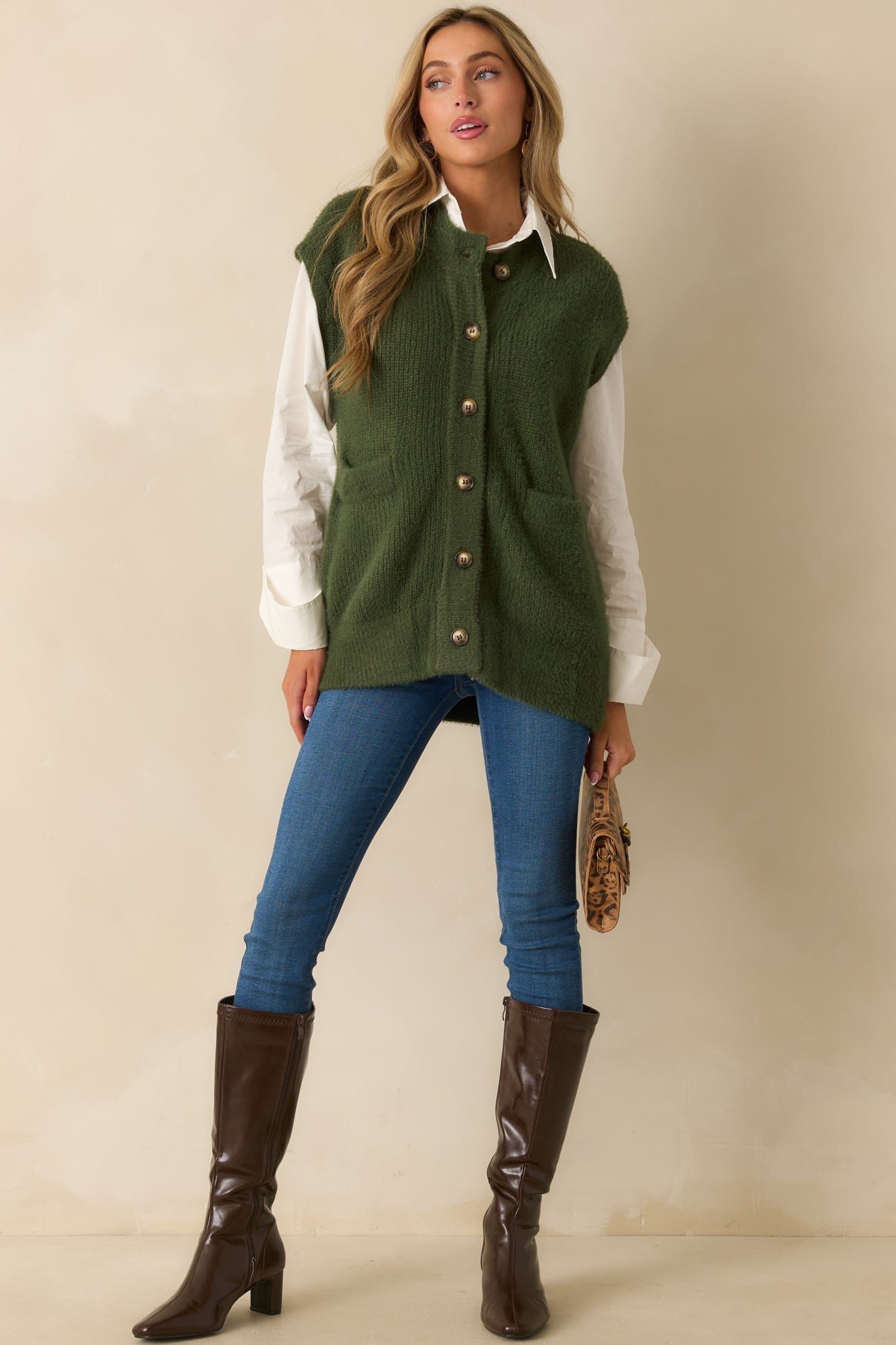 Green sleeveless knit cardigan styled front-facing to highlight its relaxed fit and button closure