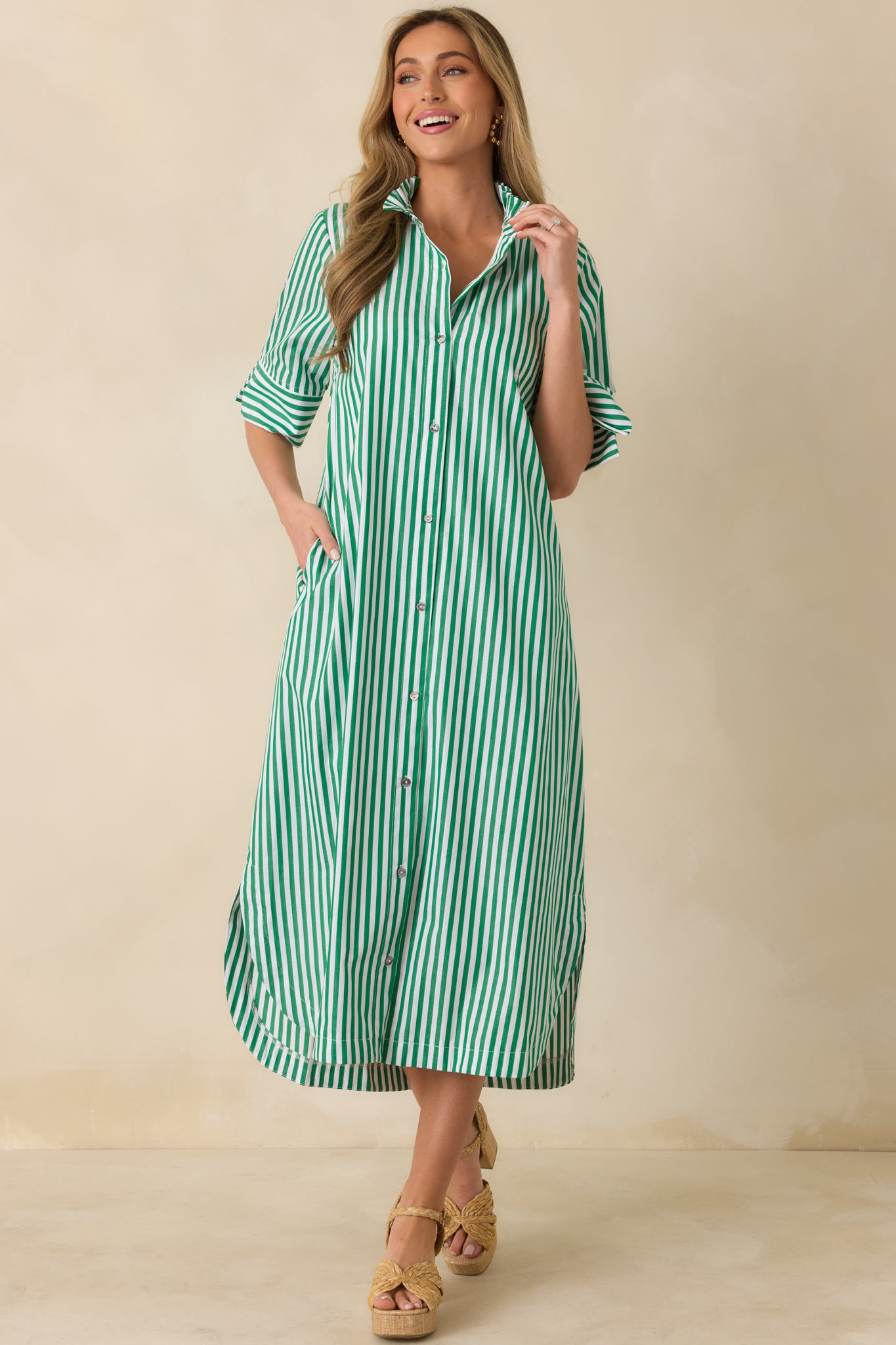 Green striped midi dress highlighting the relaxed, flowy fit through the skirt.