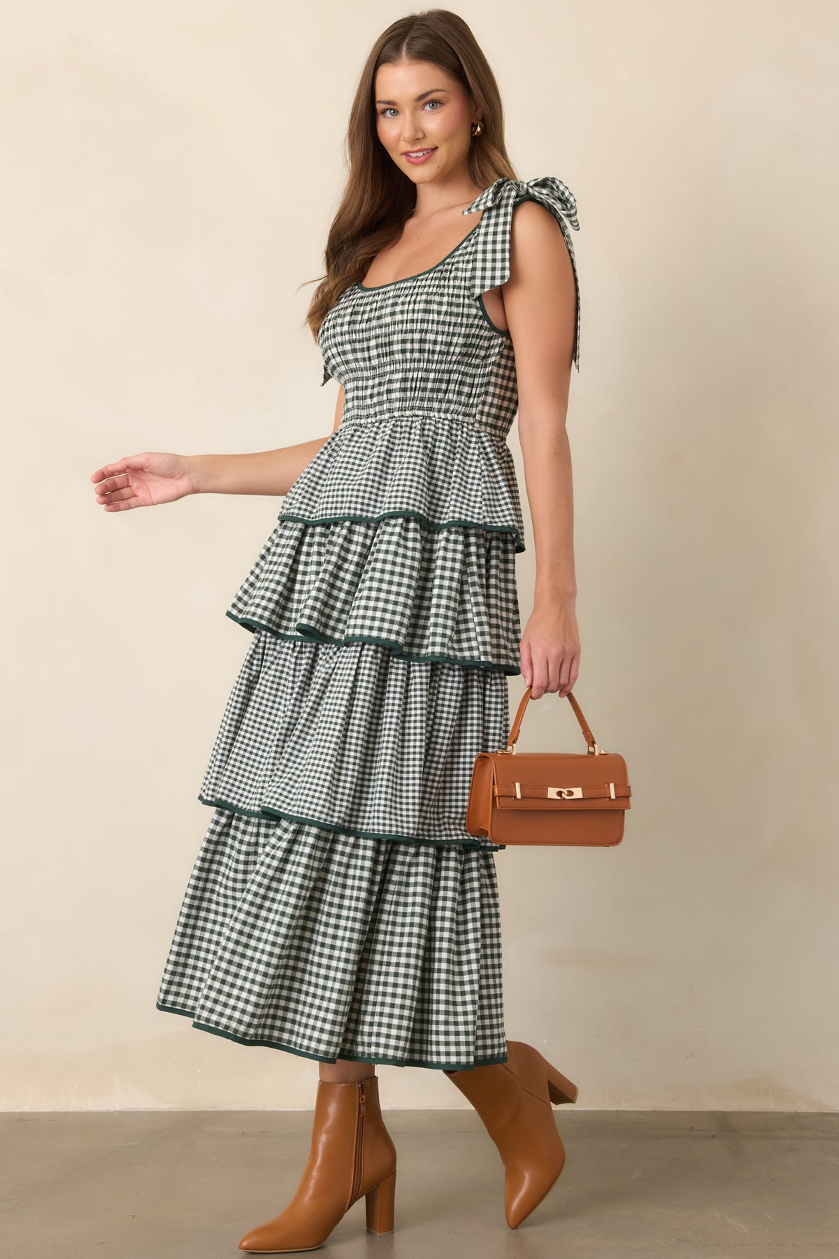 Green tiered silhouette featuring a textured smocked bodice, soft scoop neckline, comfortable waist, and playful fixed shoulder ties.