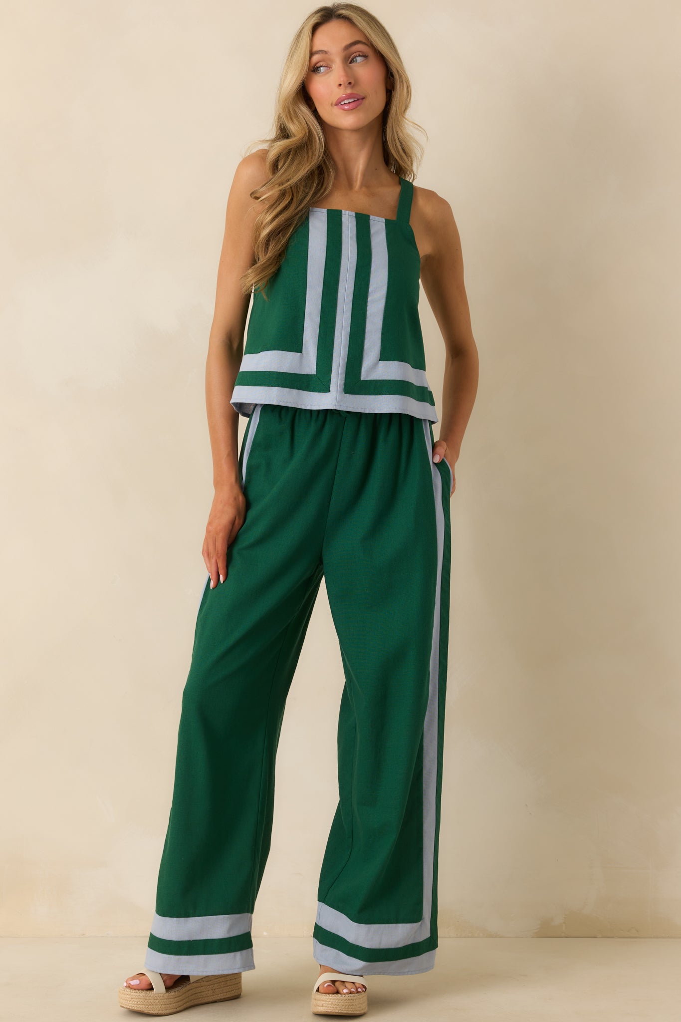 Front-facing green top highlighting elastic back insert, adjustable straps, and relaxed fit with contrast trim.