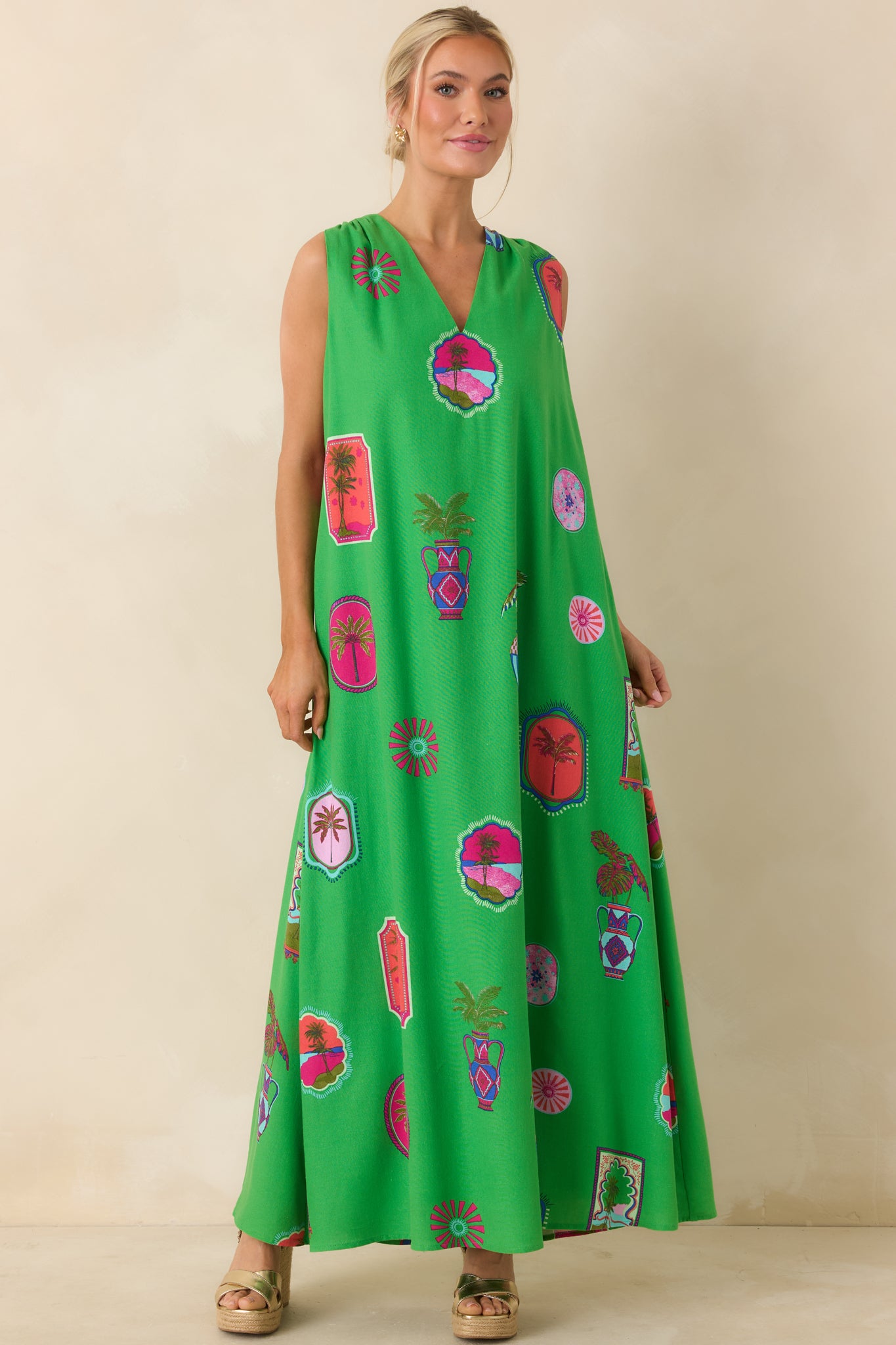 Front view of a green tropical print maxi dress with a V-neckline and sleeveless, flowy silhouette.