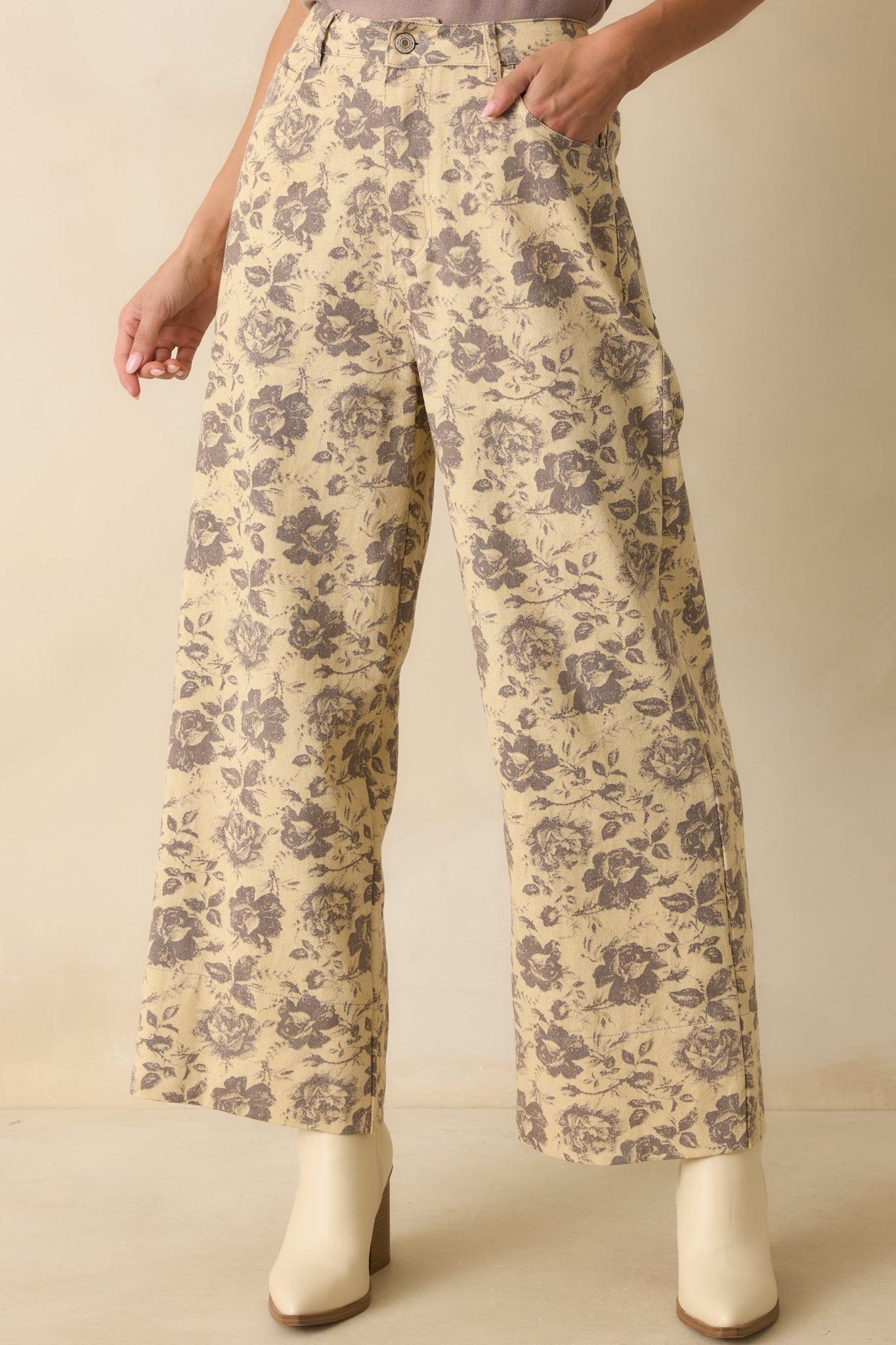 Grey floral print pants with a high-rise waist and wide-leg silhouette, showing the vintage-inspired rose pattern.