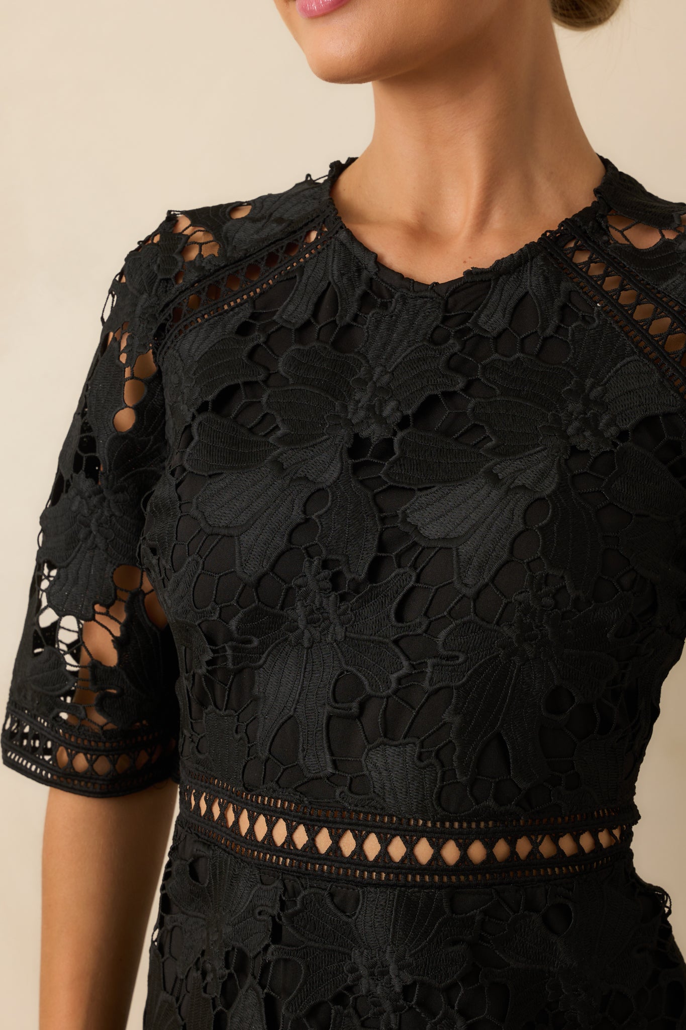 Intricate guipure lace pattern with sheer cutout detailing shown up close.