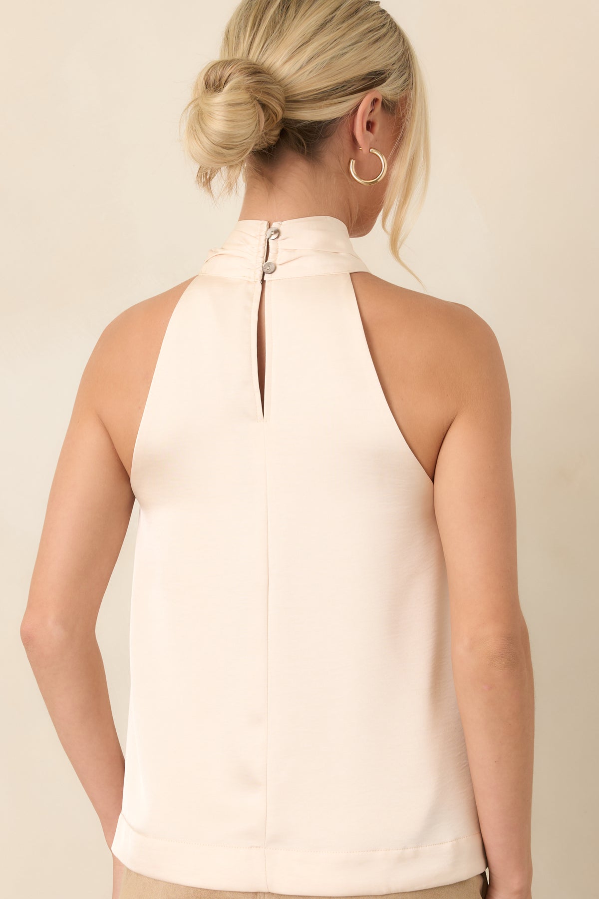 Rear view of the sleeveless halter top showing its softly draped silhouette and exposed shoulders.