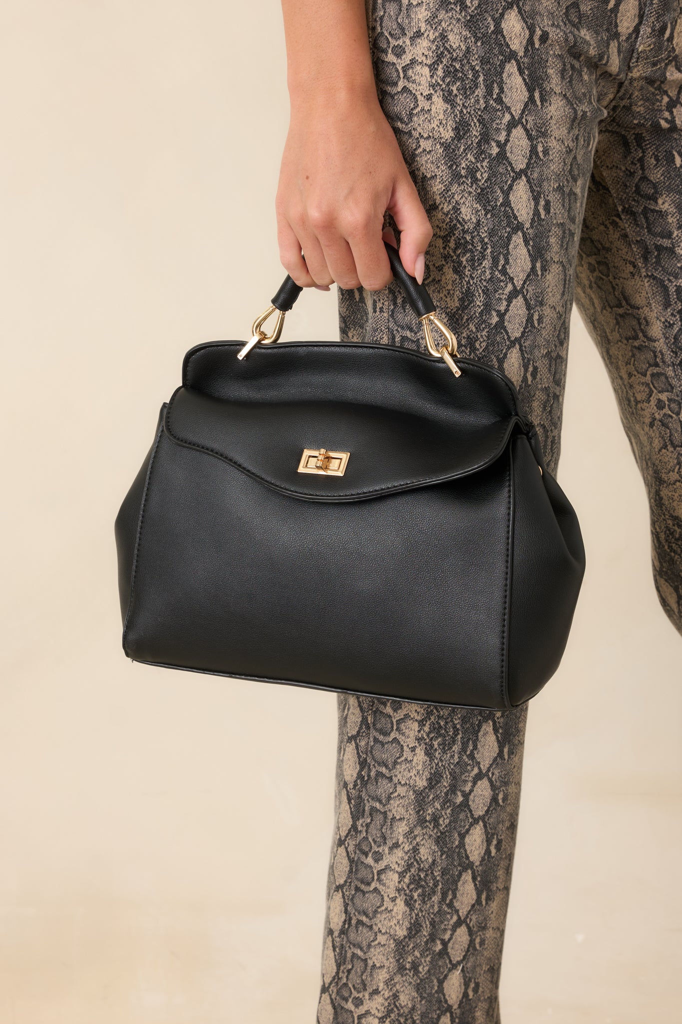 Detailed view highlighting the top handle, adjustable shoulder strap, and timeless faux leather construction.