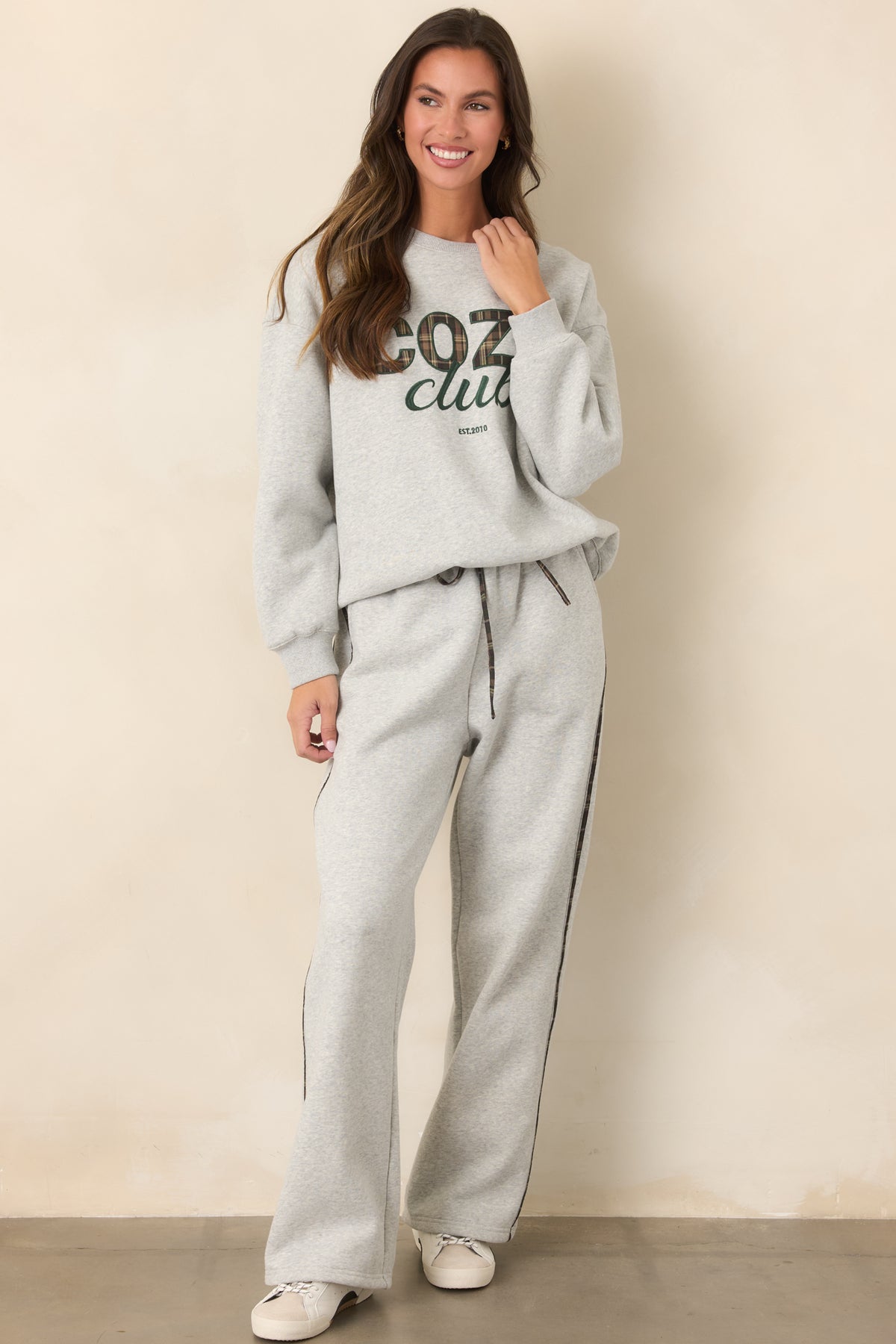 Heather grey crewneck sweatshirt showcasing plaid lettering and an easy, casual silhouette.