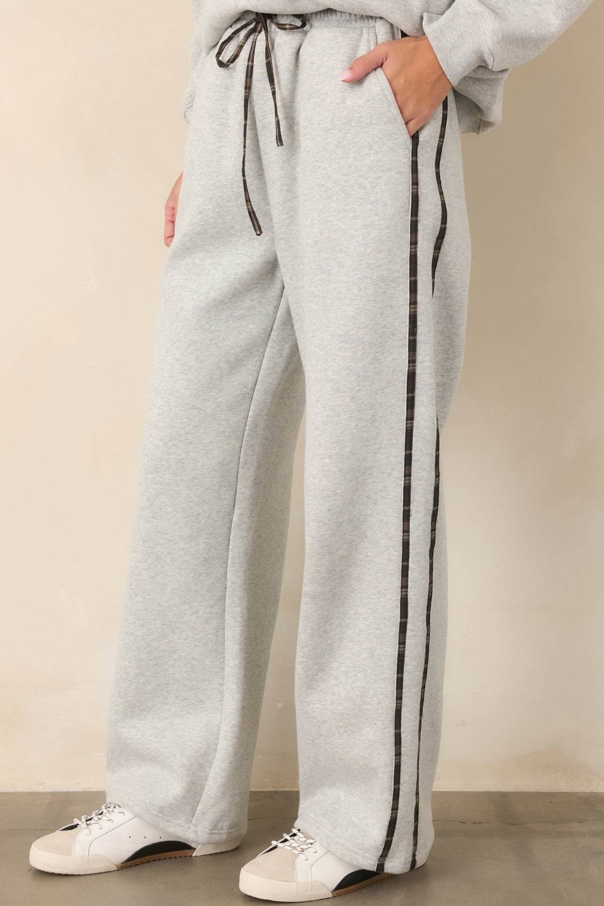 Heather grey sweatpants highlighting the elastic waistband and adjustable drawstring with subtle plaid stripe detailing.