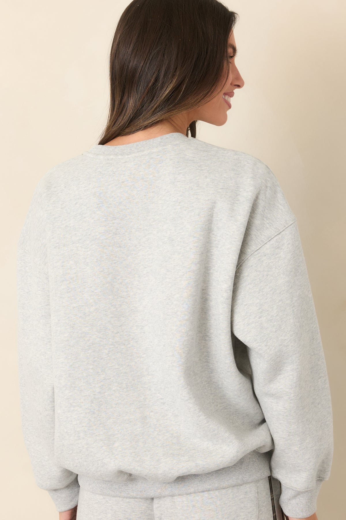 Rear of the heather grey sweatshirt showing the relaxed fit and long sleeves.
