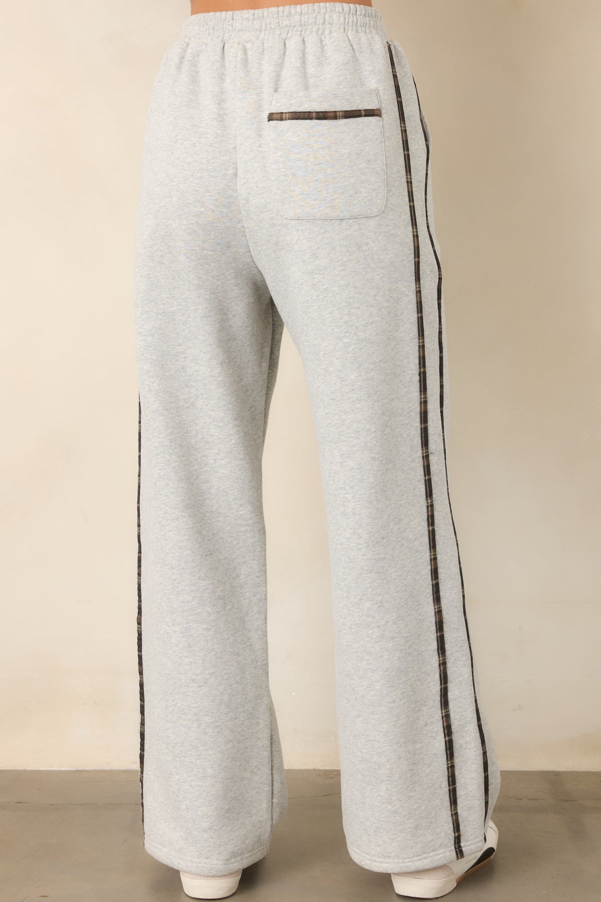 Rear of the heather grey sweatpants showing the relaxed straight-leg fit and subtle plaid stripes.