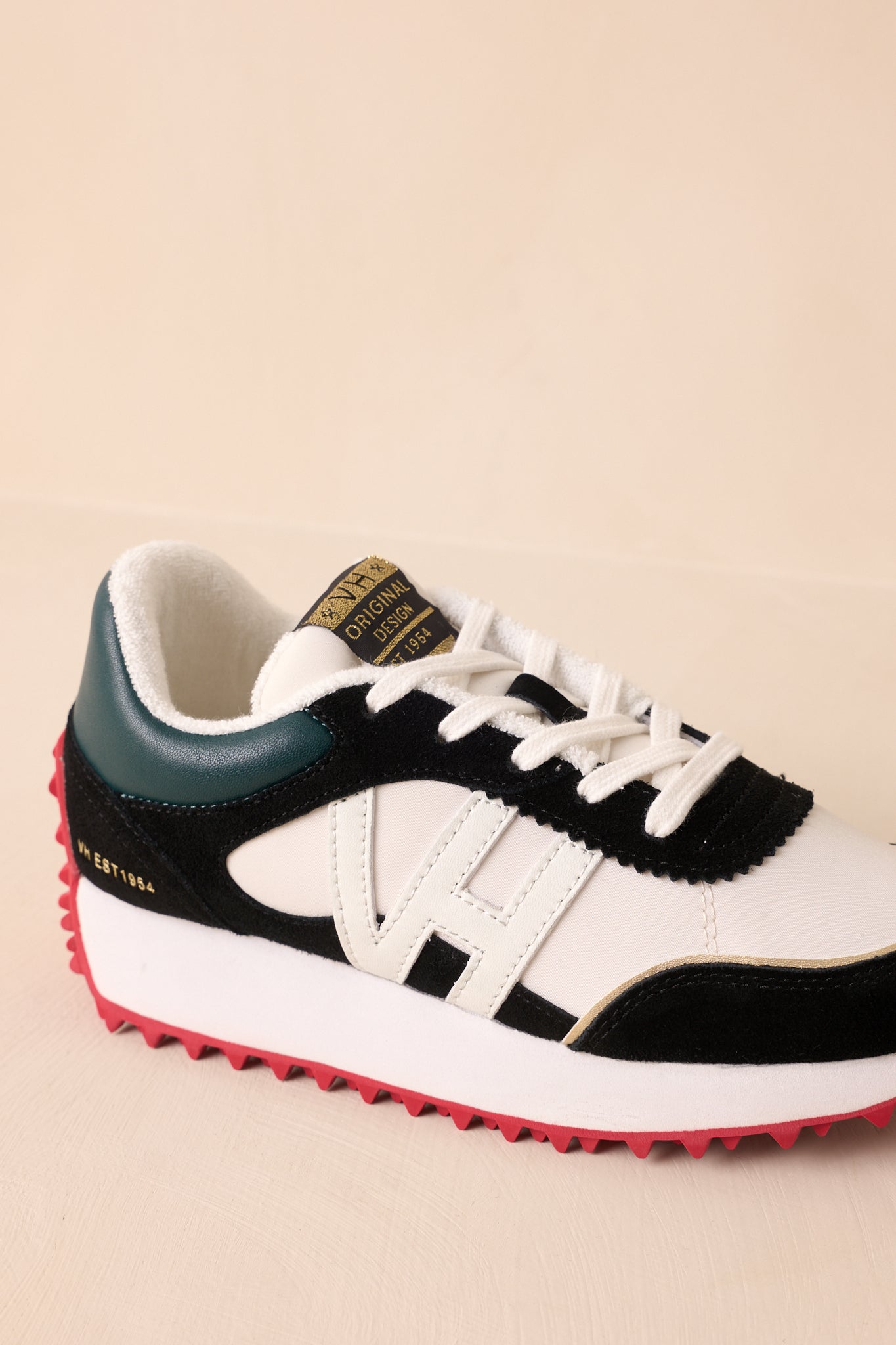 Focus on the heel area featuring the green panel and textured transition to the red sole.