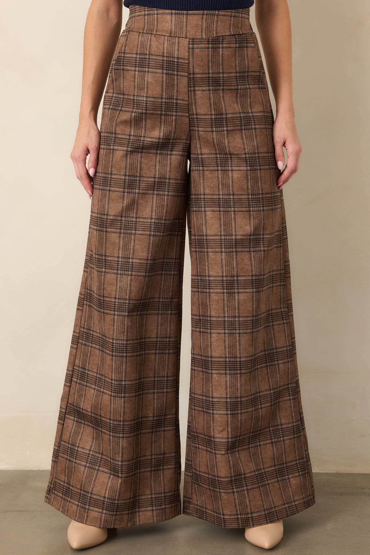 High-rise brown plaid pants featuring softly structured fabric, a smooth finish, and long wide legs.