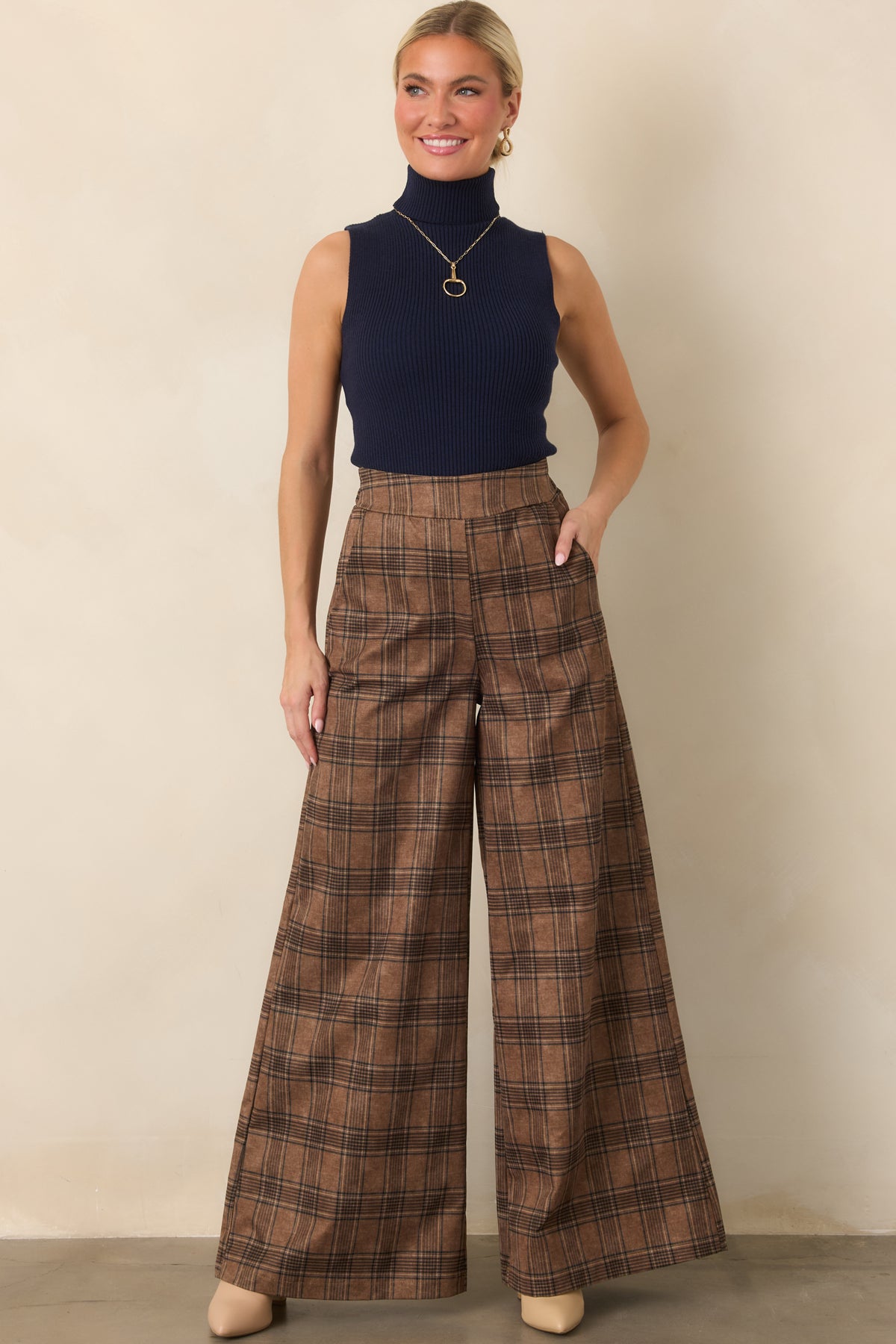 High-rise brown plaid pants with a sweeping wide-leg shape and smooth fabric offering comfortable stretch.