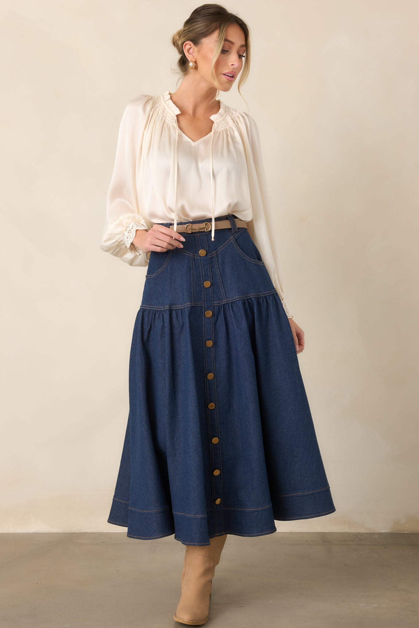 High-rise denim maxi skirt showcasing a polished button-front closure, belt loops, practical pockets, and a flowing hemline.