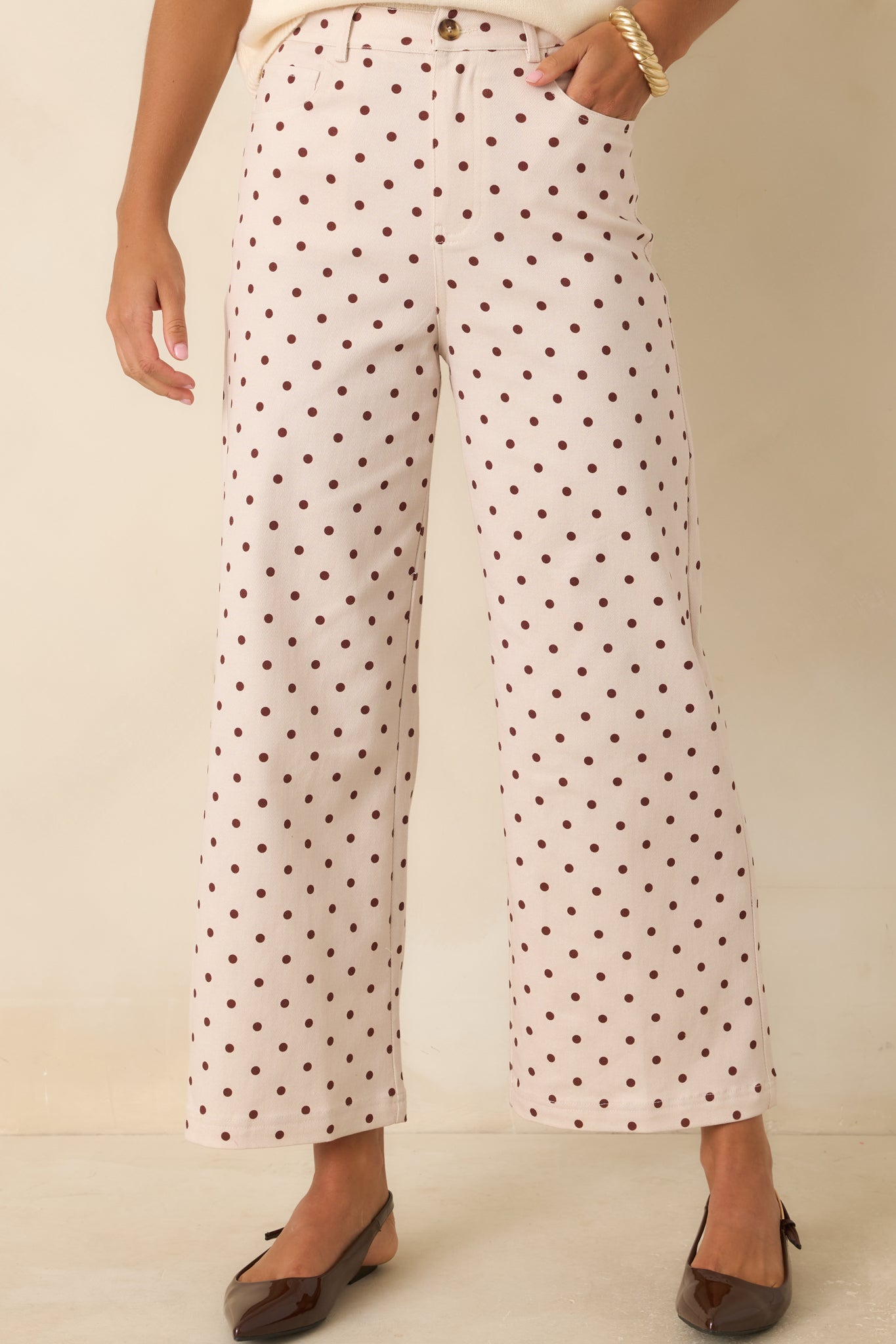 High-rise waistband features belt loops, button closure, and zip detail on these polka dot pants.