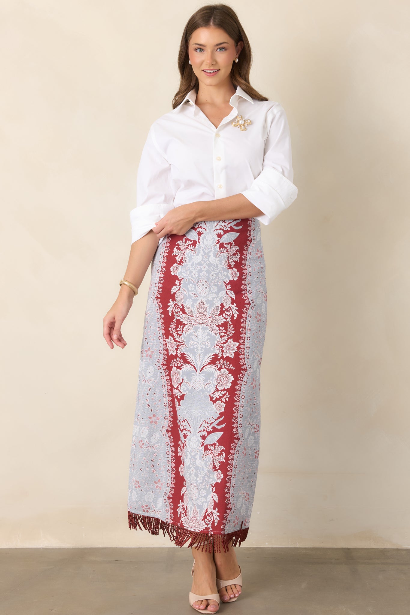 High-rise cotton-linen midi skirt with a sleek column silhouette and fringe-trimmed hem that adds texture and movement.