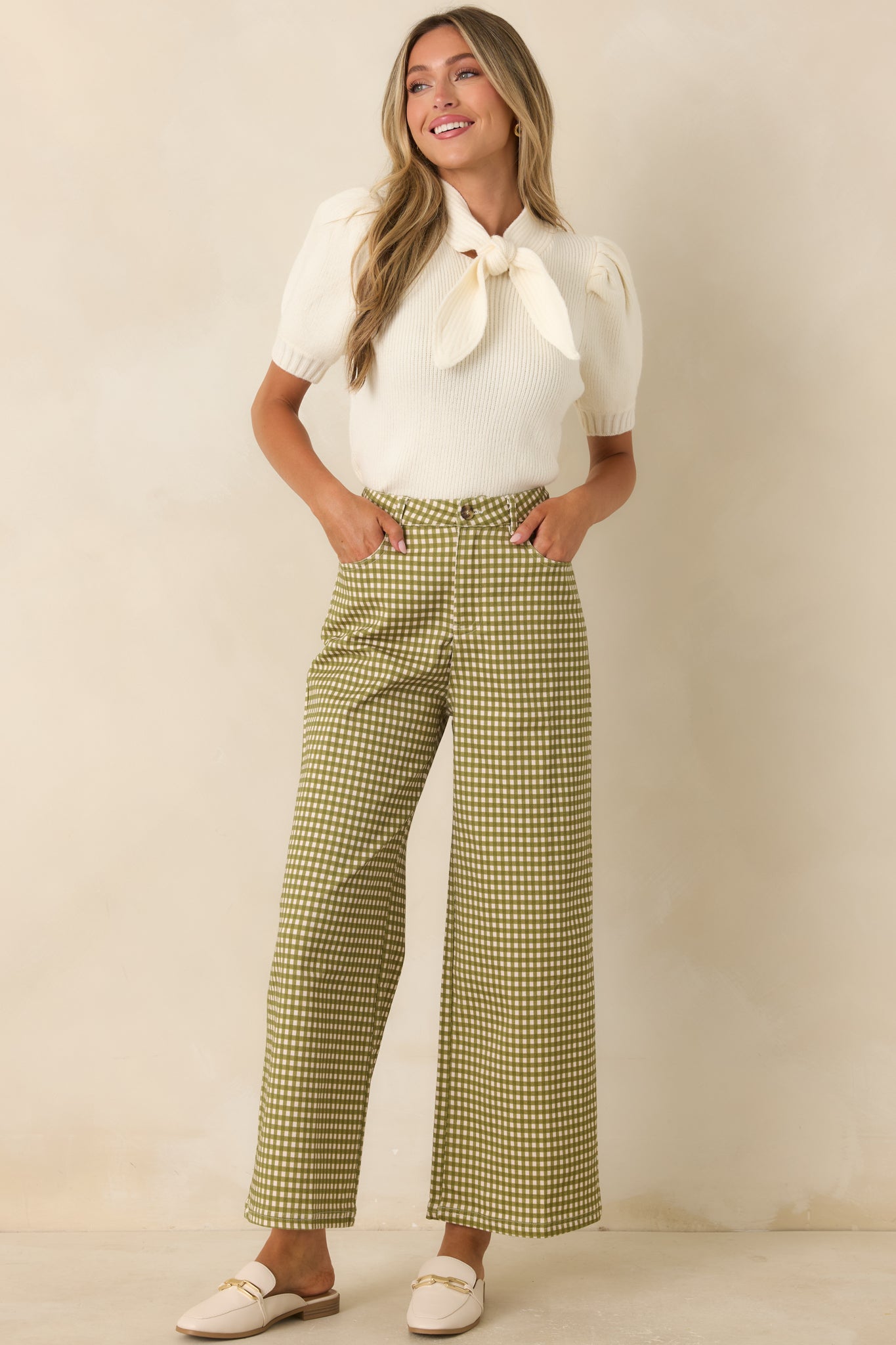 High-rise gingham pants showcasing a relaxed silhouette, functional pockets, belt loops, and zip-button closure.