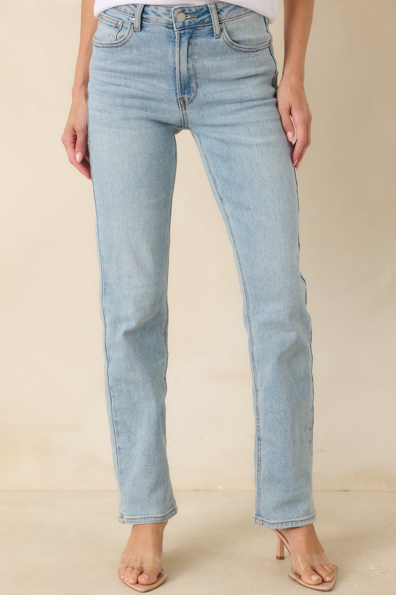 High rise jeans showcasing the classic denim construction, zipper closure, and tailored straight leg shape.
