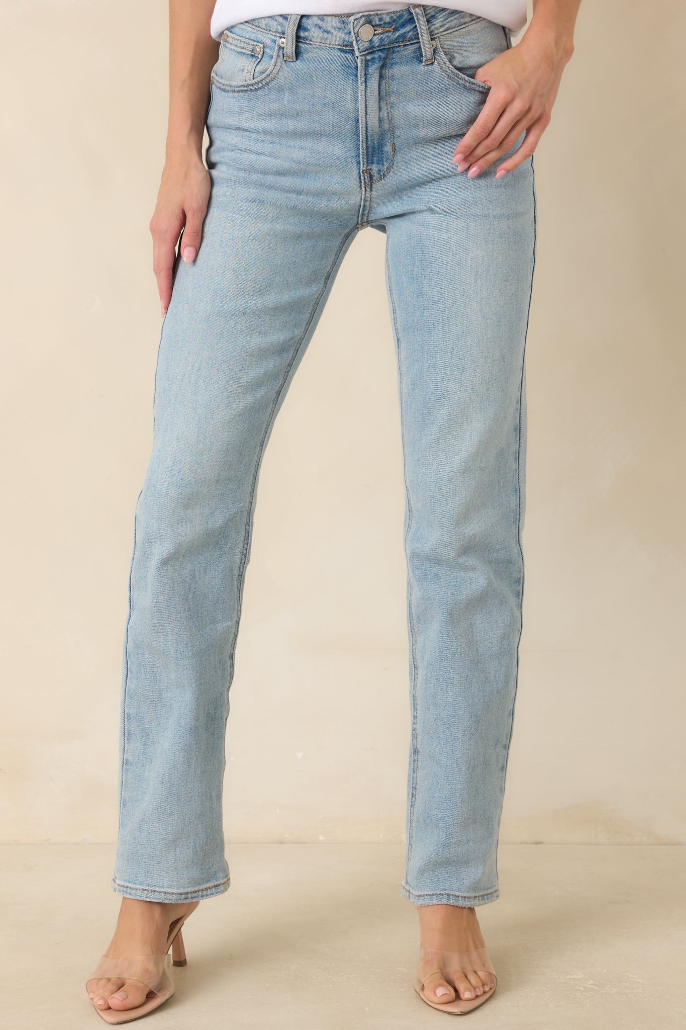 High rise jeans showcasing the classic denim construction, zipper closure, and tailored straight leg shape.