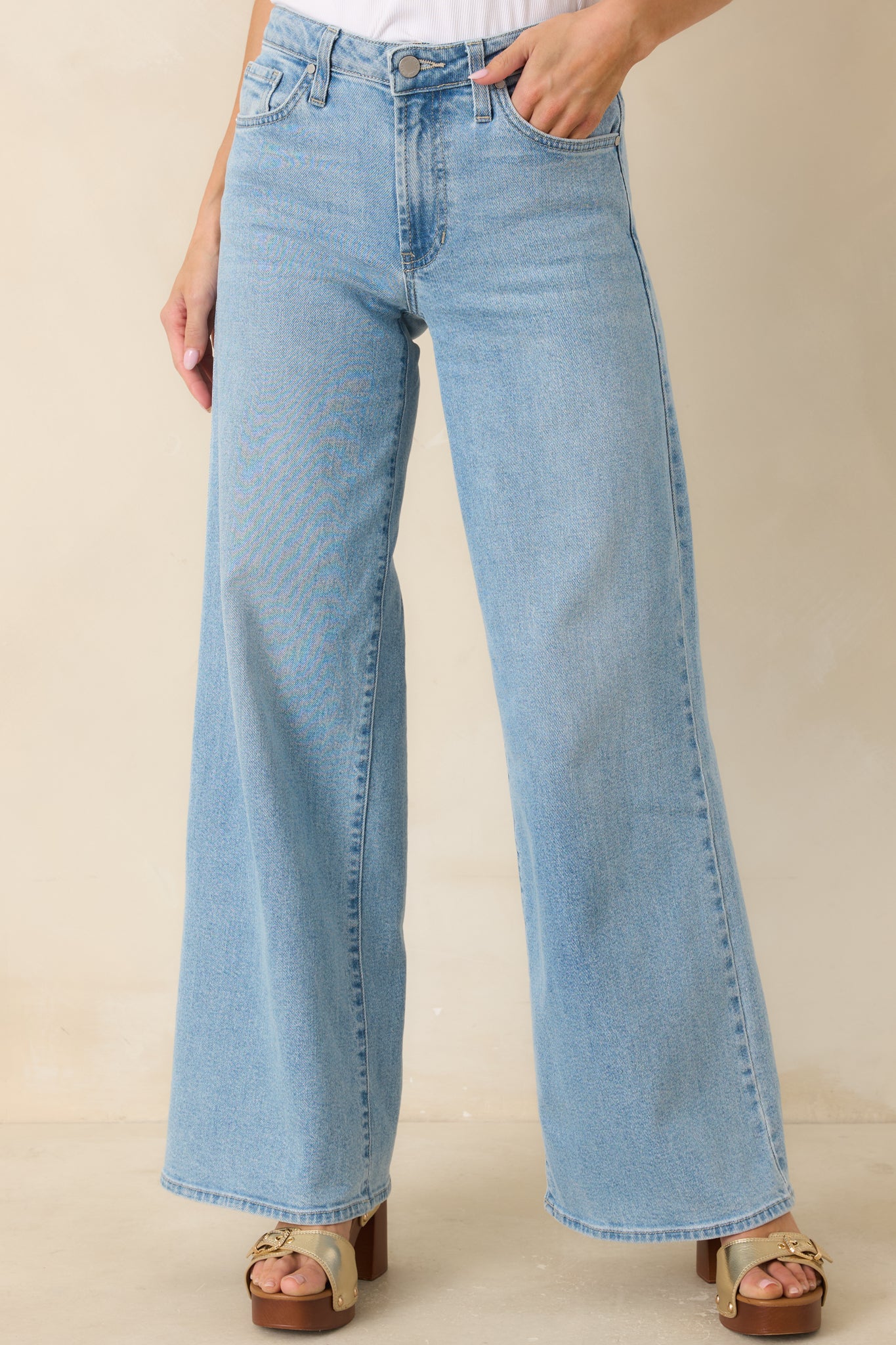 Comfortable high-rise light wash jeans highlighting the relaxed wide leg silhouette and classic denim finish.