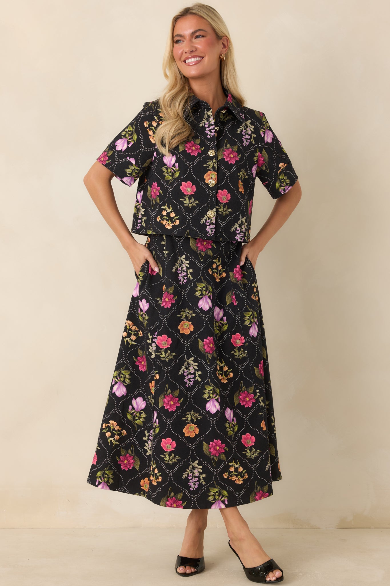 High-rise maxi skirt featuring a colorful botanical print on a black background with a flowing A-line silhouette.