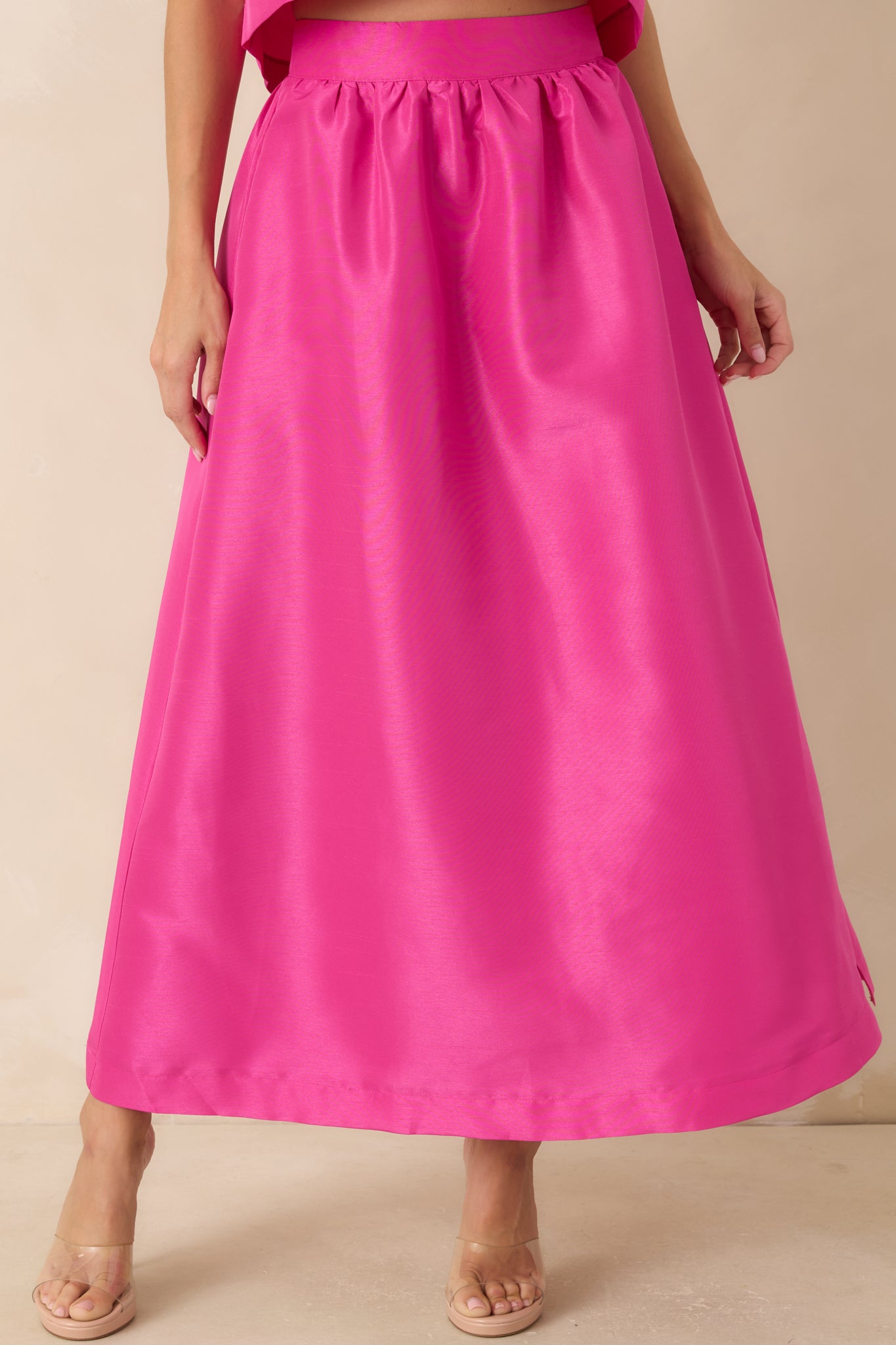 High-rise maxi skirt featuring functional side pockets and a polished flowing silhouette.