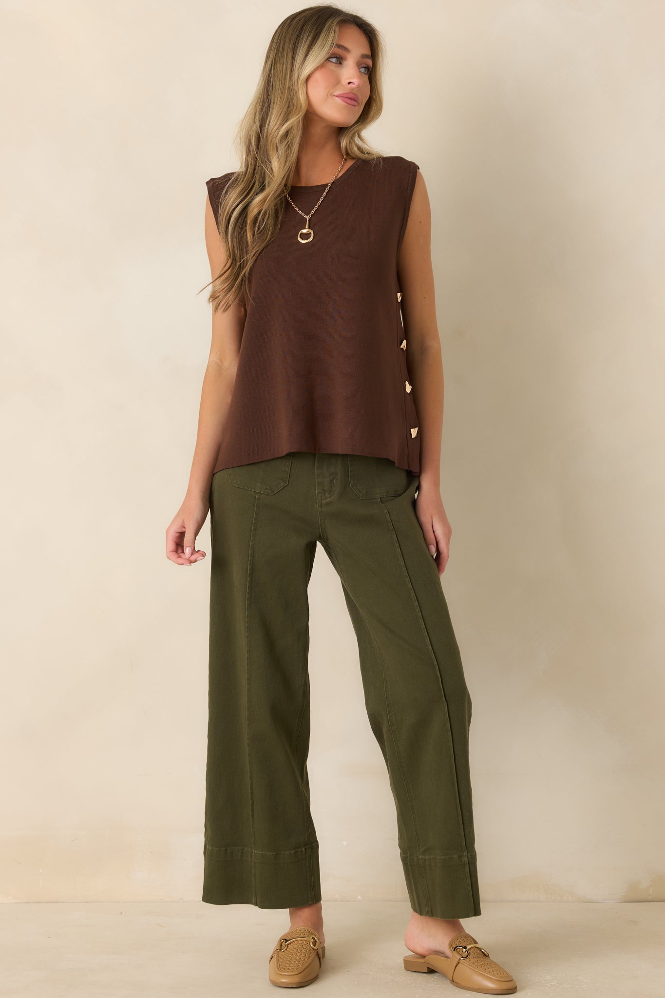 High-rise olive pants with pressed center seams, utility-inspired front pockets, belt loops, and a polished tailored silhouette.