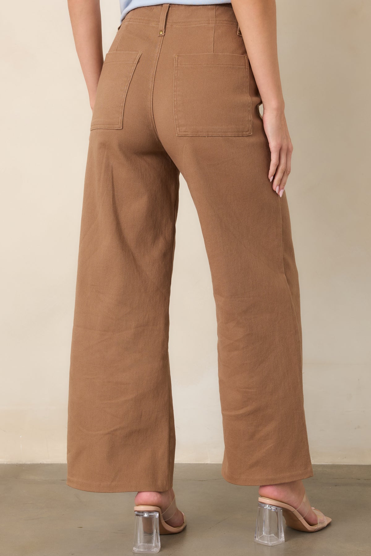 Rear view of the high-rise pants featuring oversized back patch pockets, belt loops, and a clean, streamlined silhouette.