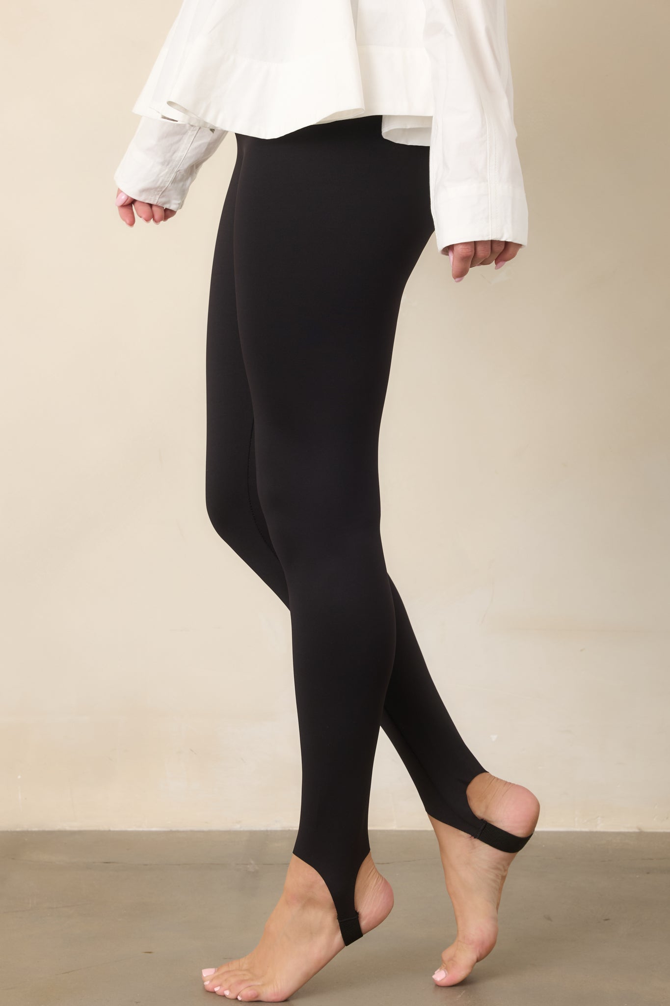 Close view of the high-rise pants highlighting their smooth fit, stretchy fabrication, and streamlined silhouette.