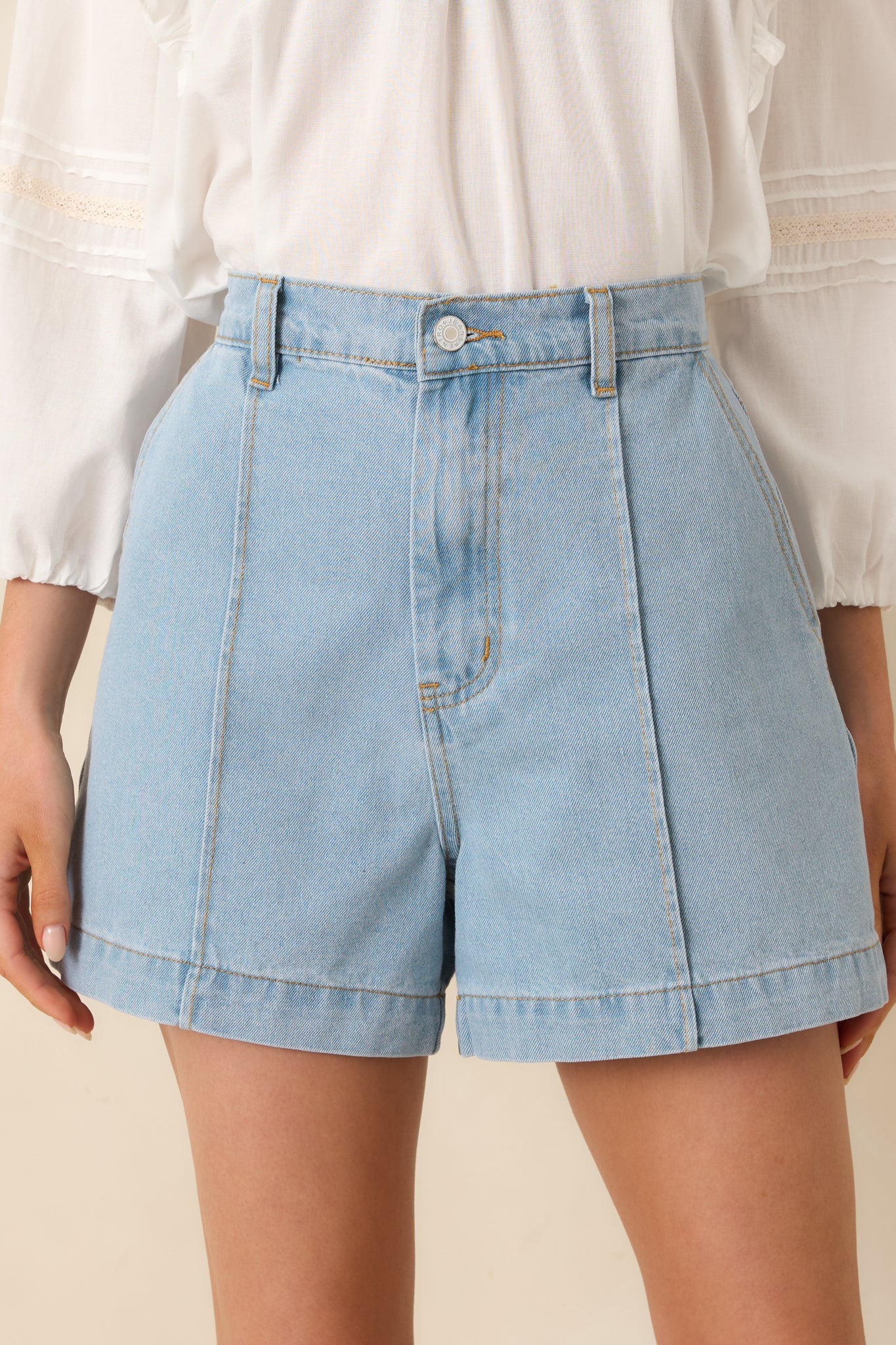 High-rise shorts, highlighting the front pocket design and structured seam detailing.