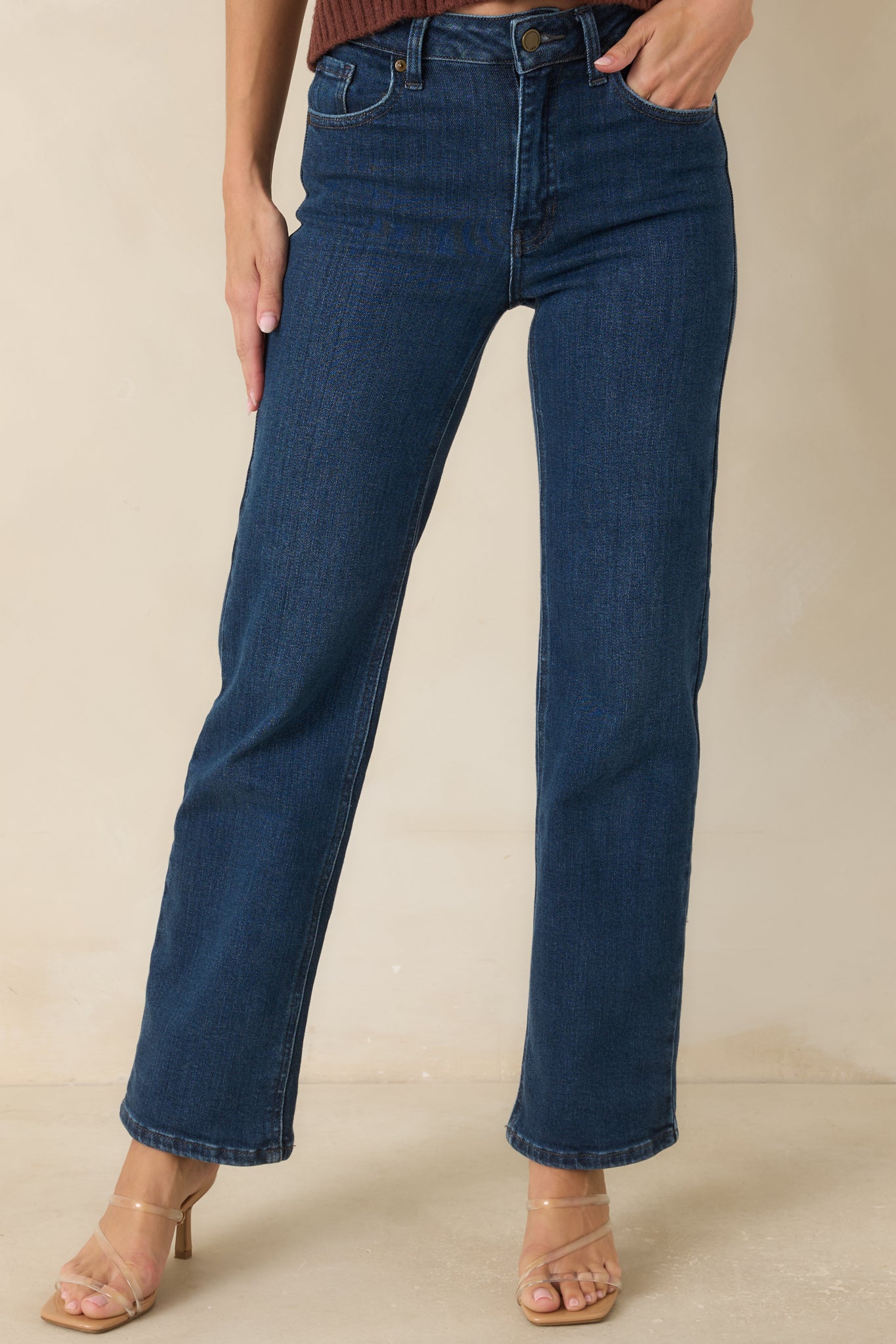 Detailed view of the high-rise waistband showcasing the button closure, zip fly, and denim construction.