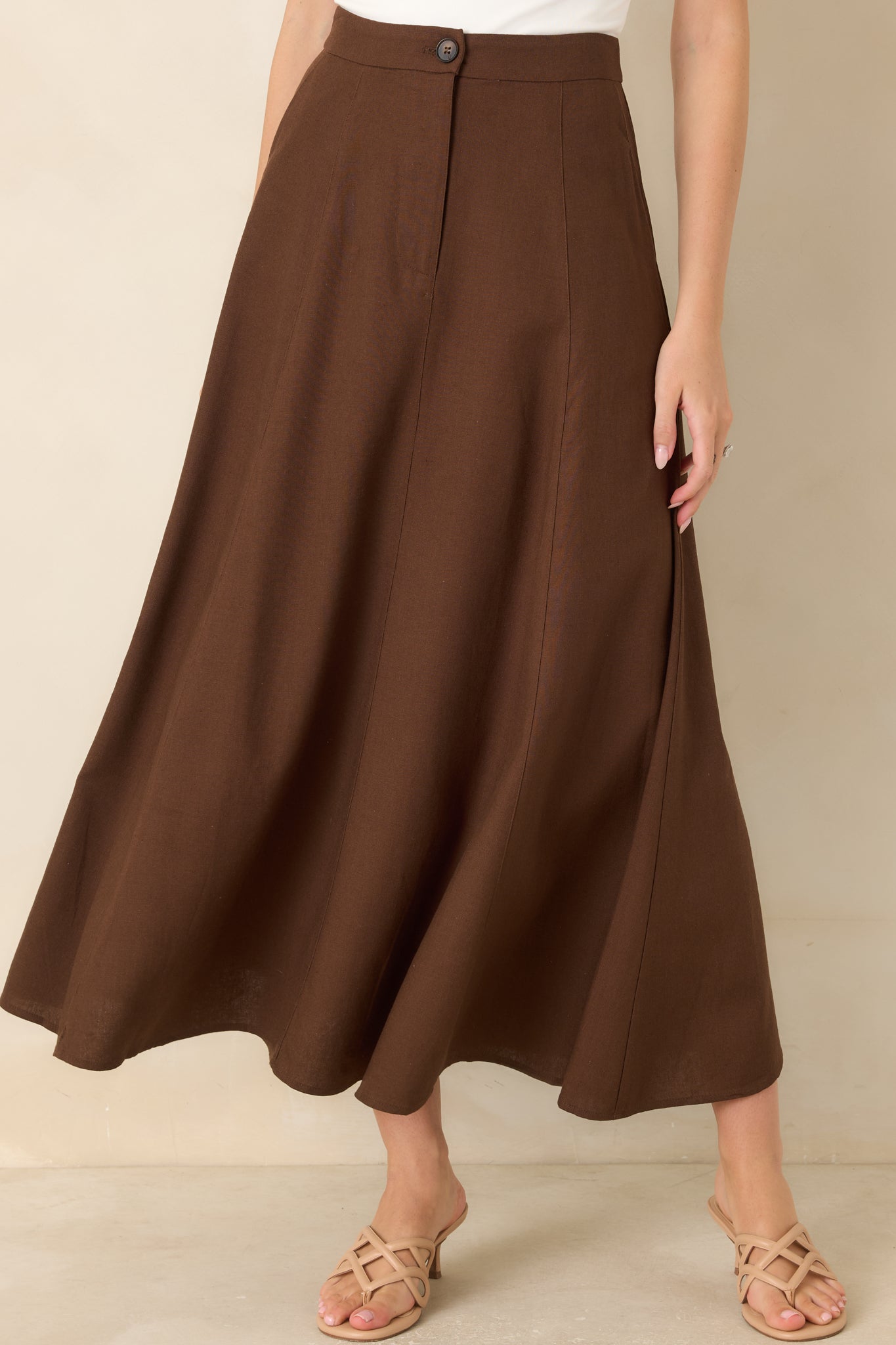 Close view of the high-rise waistband highlighting the coordinating button, concealed zip-front closure, and tailored linen blend construction.