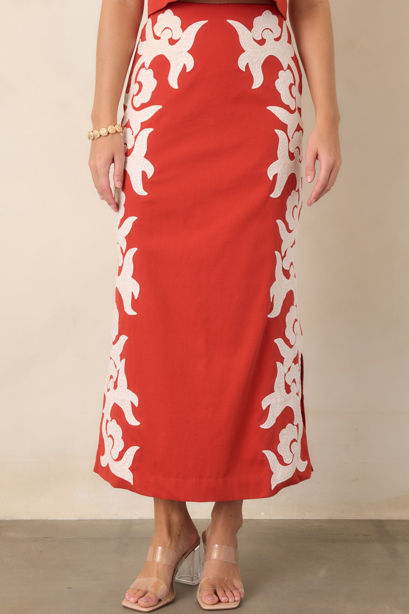 High-waisted design showcases the smooth cotton construction and bold ivory appliqué accents across the skirt.