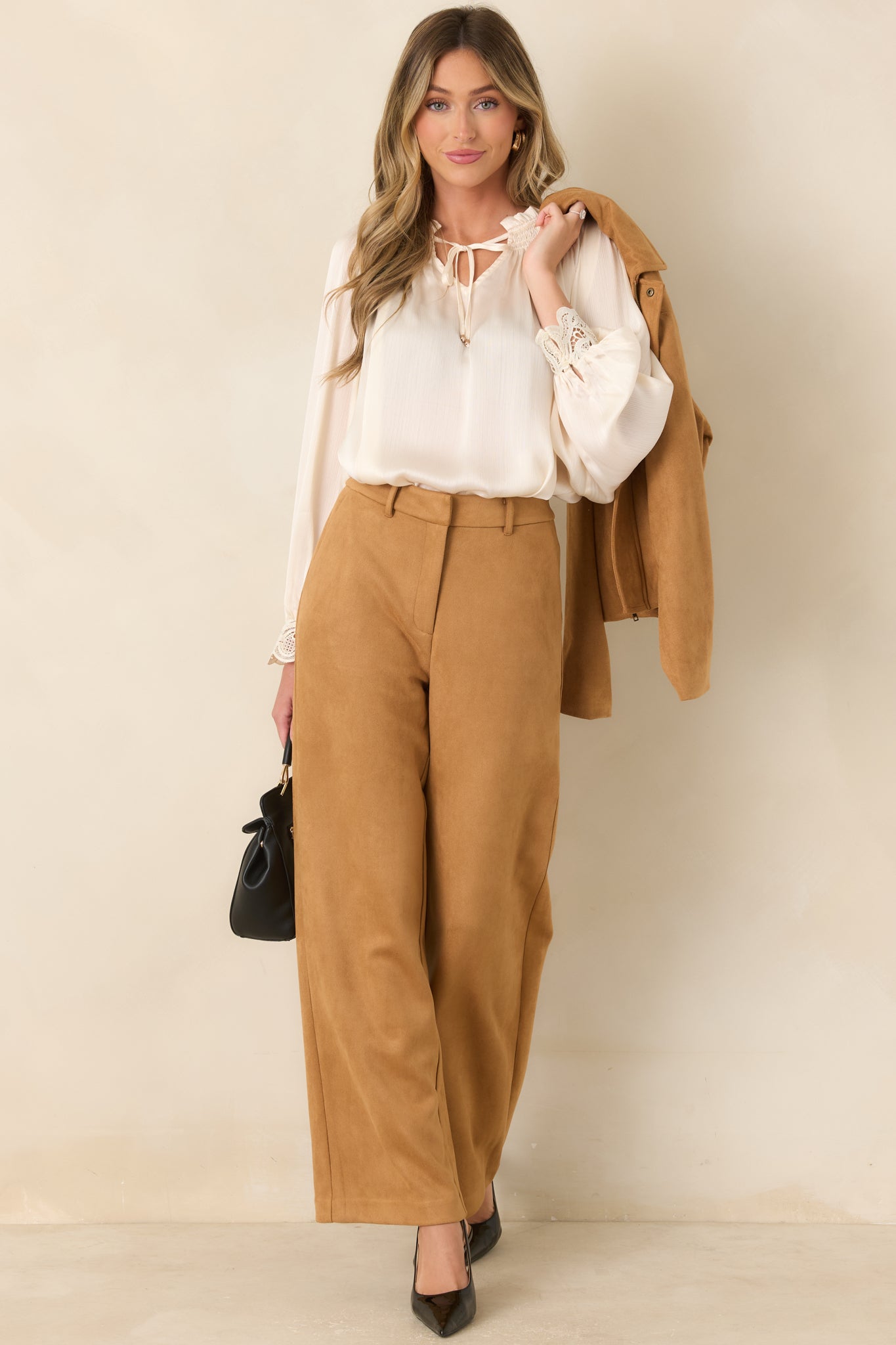 Wide-leg trousers showcasing a clean high-rise waist, concealed front closure, practical pockets, and an elongated silhouette.