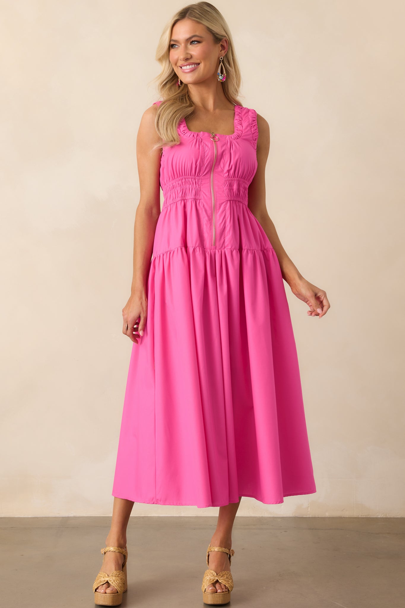 Complete front view of a hot pink dress with a fitted top, flowy skirt, and decorative zipper with o-ring pull.
