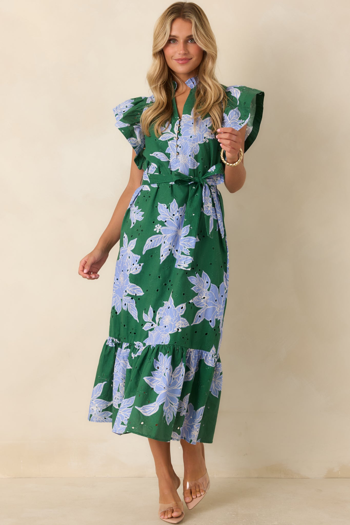 Hunter green and blue floral dress showcasing cotton fabric, gold button details, belted waist, and ruffle hem.