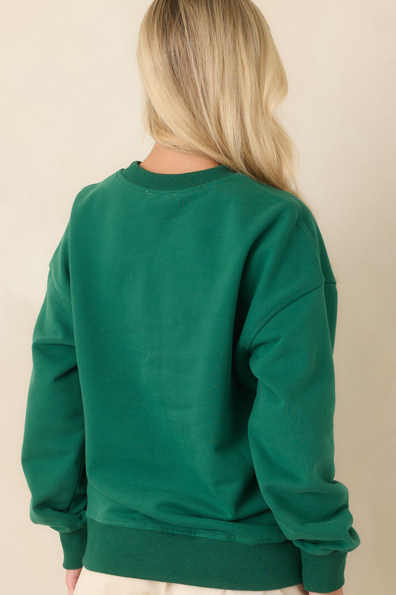 Rear view of the hunter green cotton sweatshirt featuring dropped shoulders, long sleeves, ribbed trim, and a clean back design.
