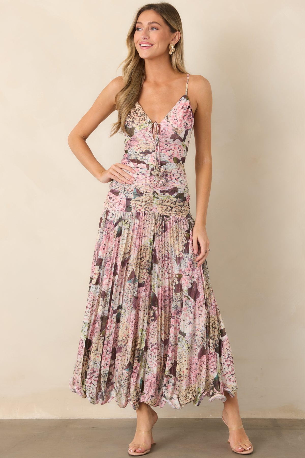 Hydrangea-inspired floral dress featuring delicate shoulder straps, a ruched bodice, softly flowing maxi skirt, and structured wavy hem.