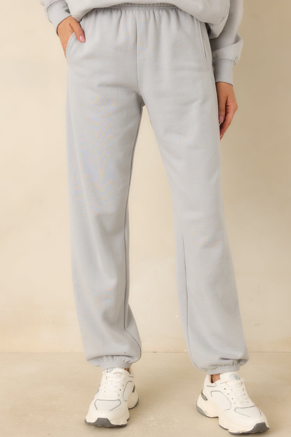Icy grey joggers highlighting the elastic waistband and smooth cotton-blend fleece fabric.