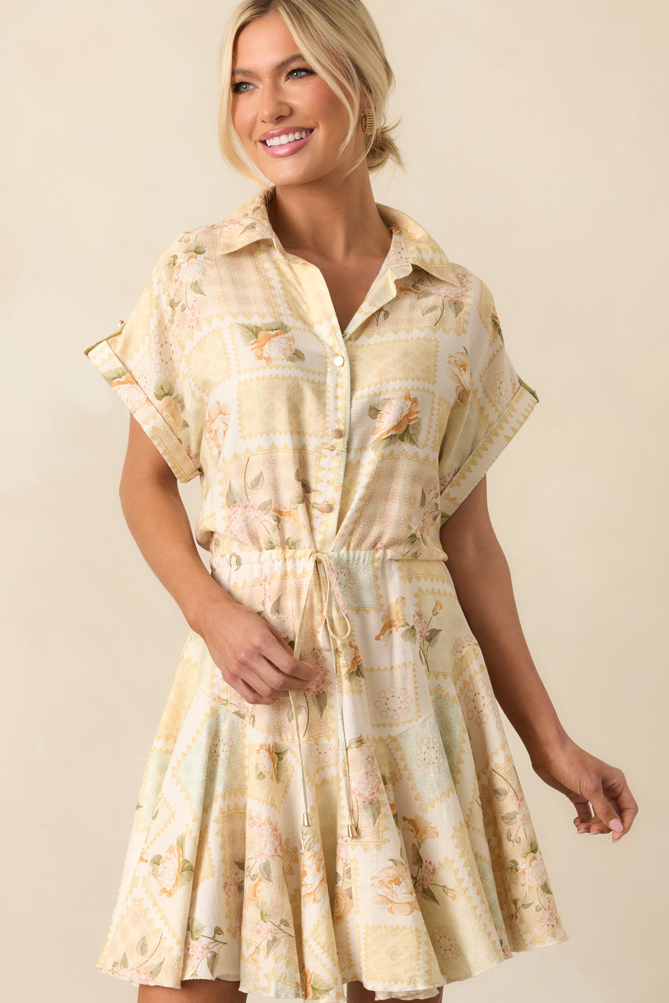 A mid-frame image focusing on the upper half of the yellow dress, emphasizing the collared neckline and gold button detailing.