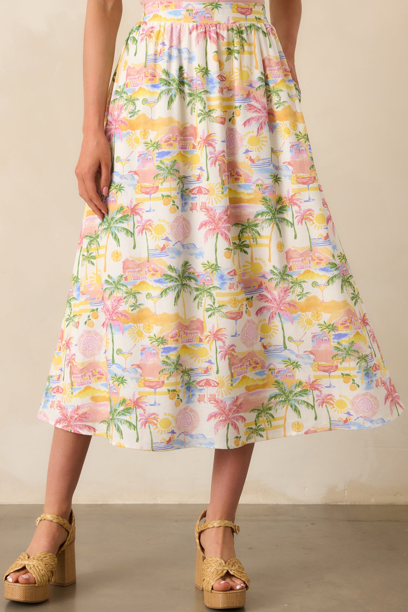 Lower half crop showing the soft flow of the maxi skirt and how the tropical print spreads across the ivory fabric.