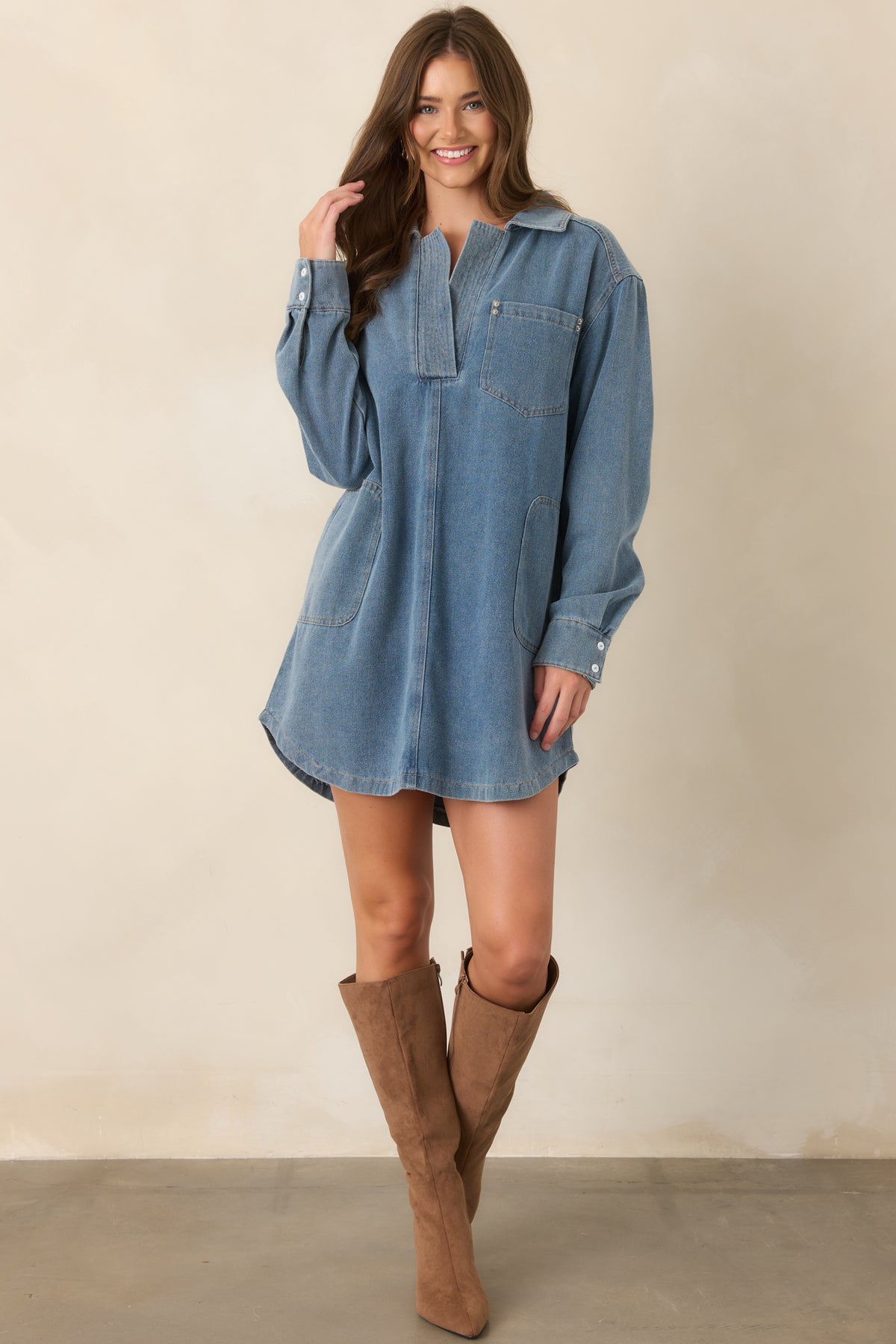 Relaxed denim mini dress in medium indigo with a polished collared neckline, long cuffed sleeves, oversized fit, and straight hem.
