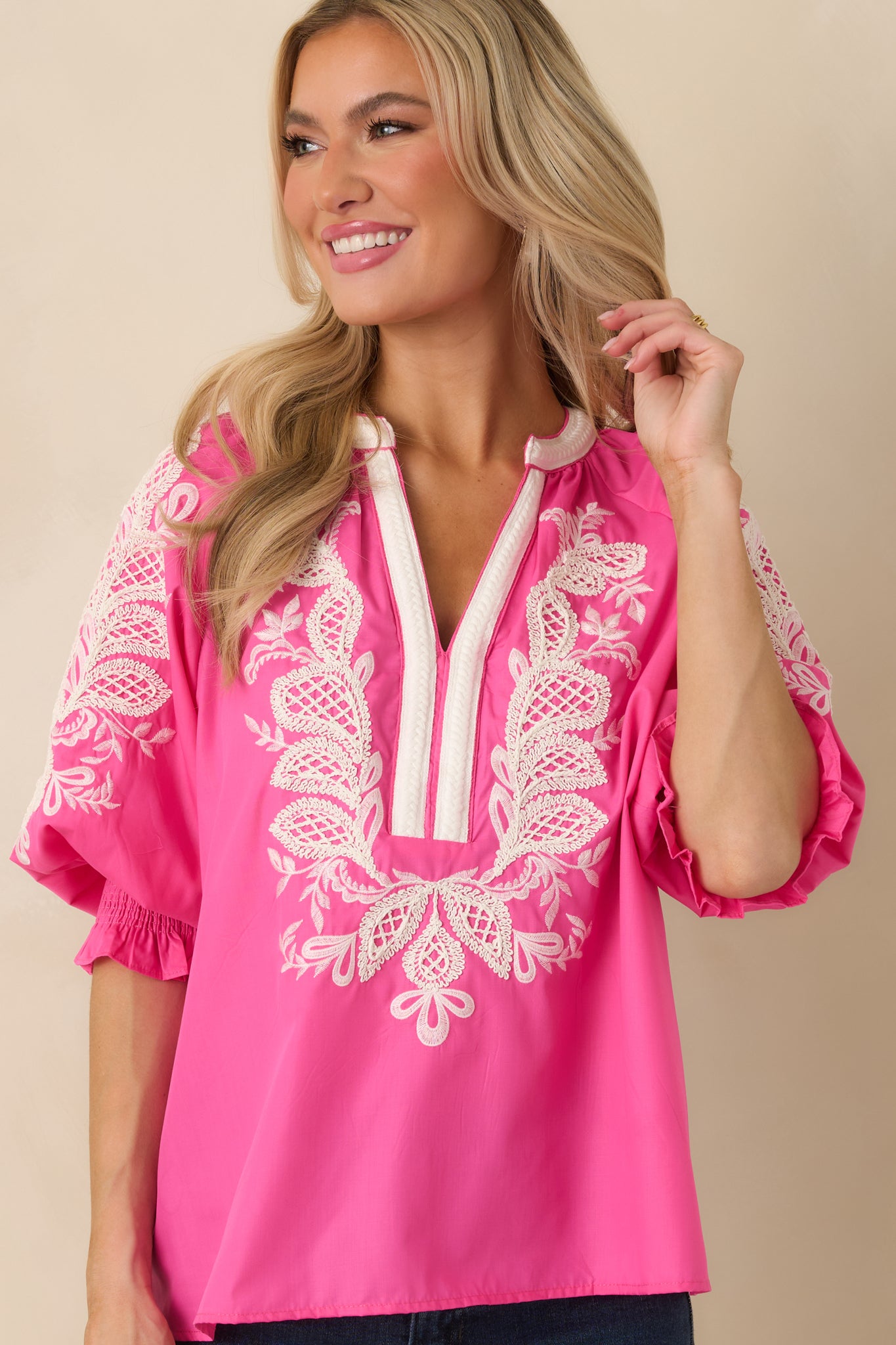 Intricate embroidery pattern displayed on the pink top, emphasizing its feminine design.